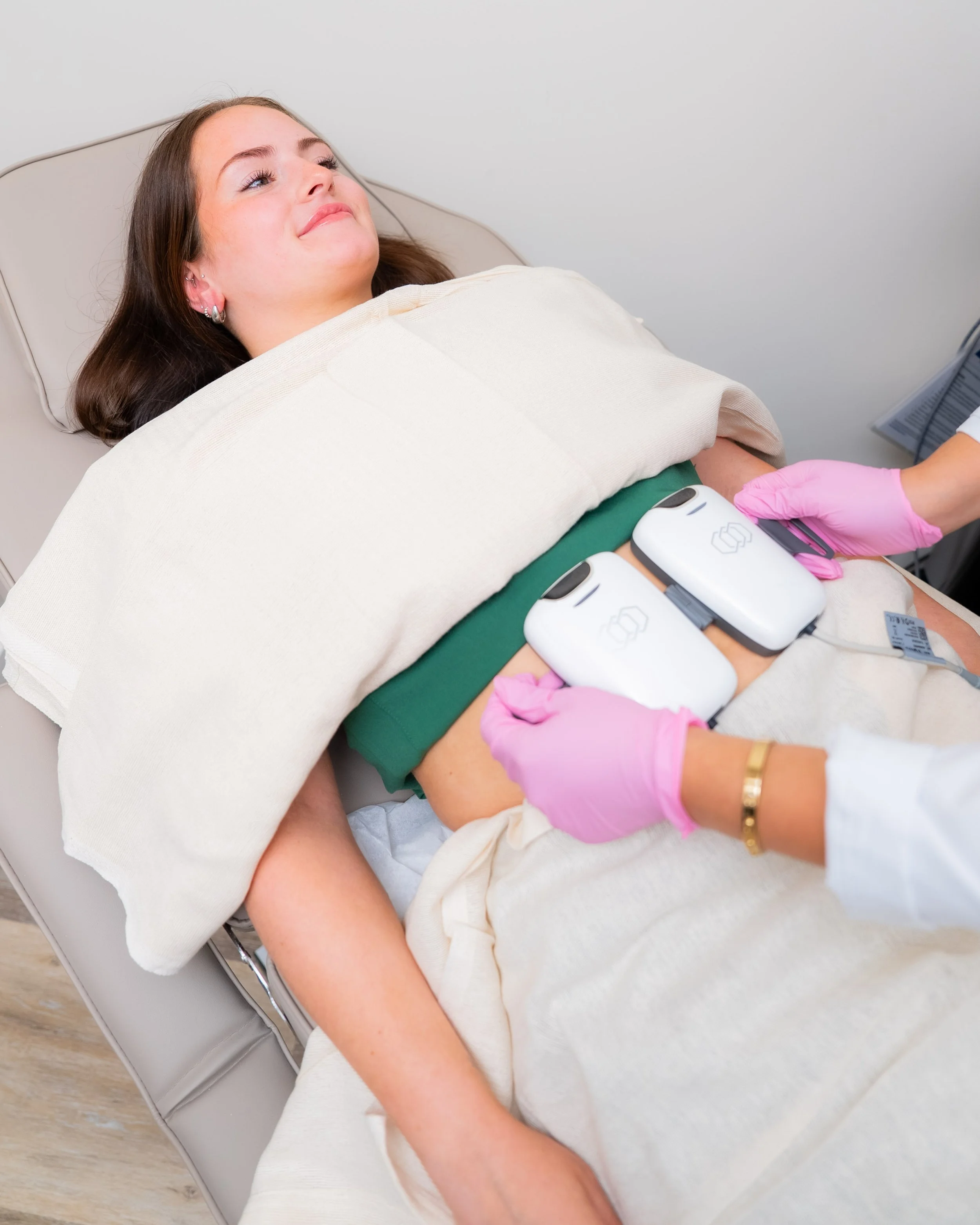 Patient receiving InMode Tone muscle stimulation treatment for body contouring and muscle strengthening at Dee Luxe Medical in Worcester, MA