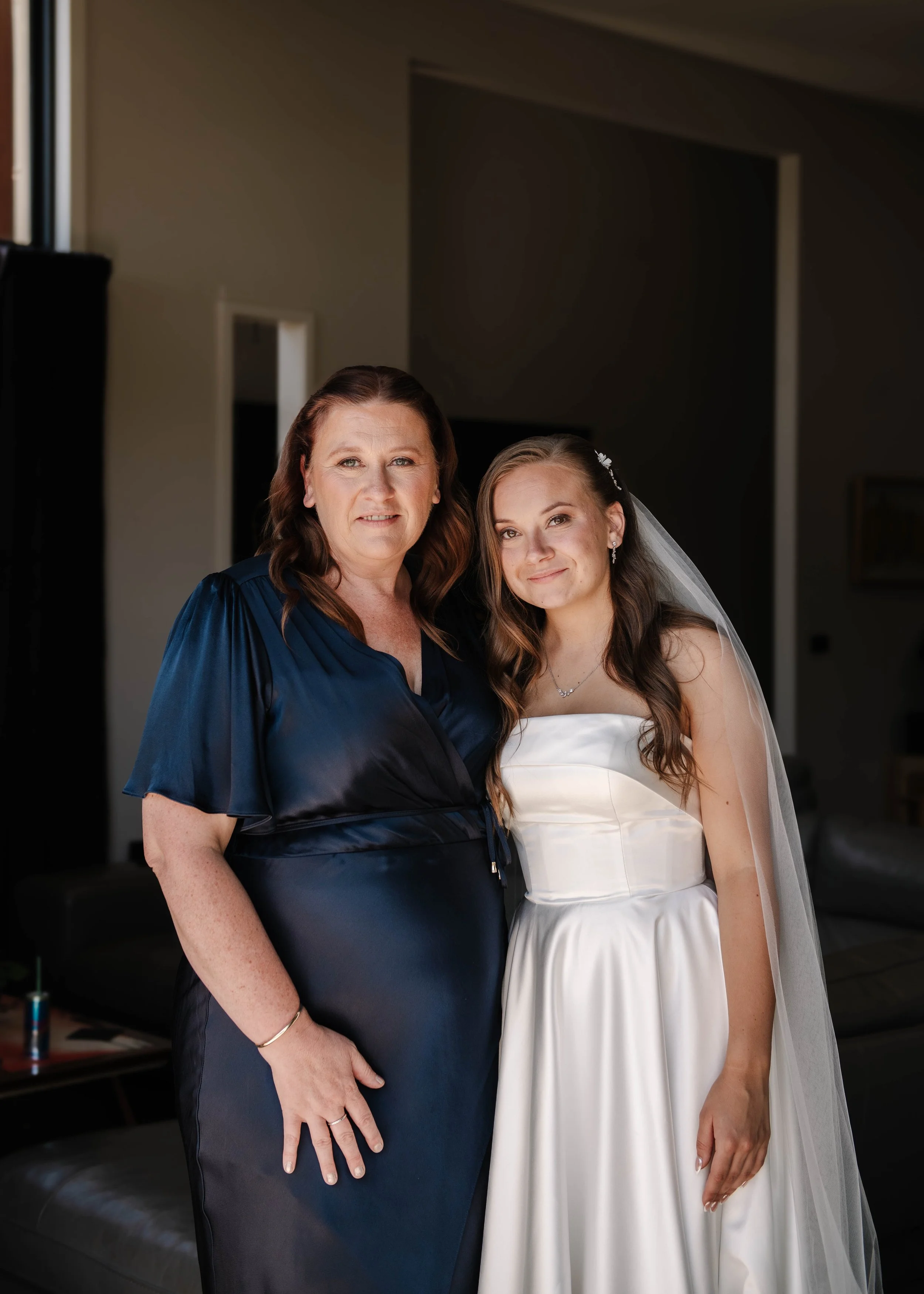 Mother of the bride poses with her daughter in navy blue dress