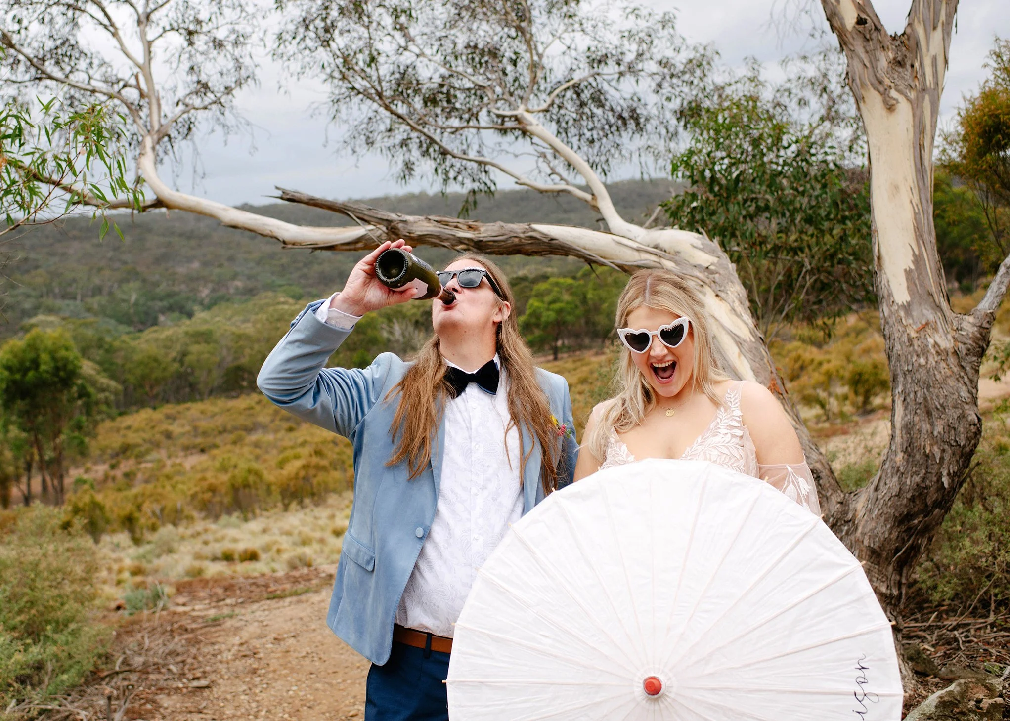 groom-drinking-from-champagene-bottle-bride-parasol copy.jpg