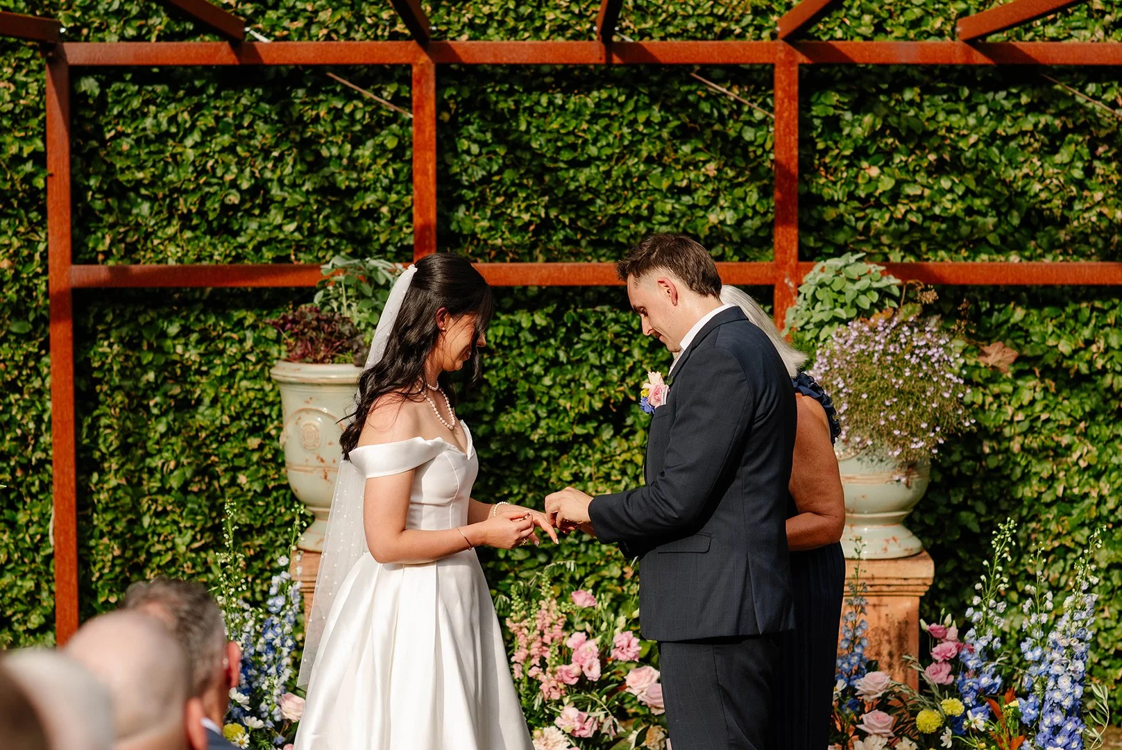 groom-puts-brides-ring-on-at-garden-ceremony.jpg
