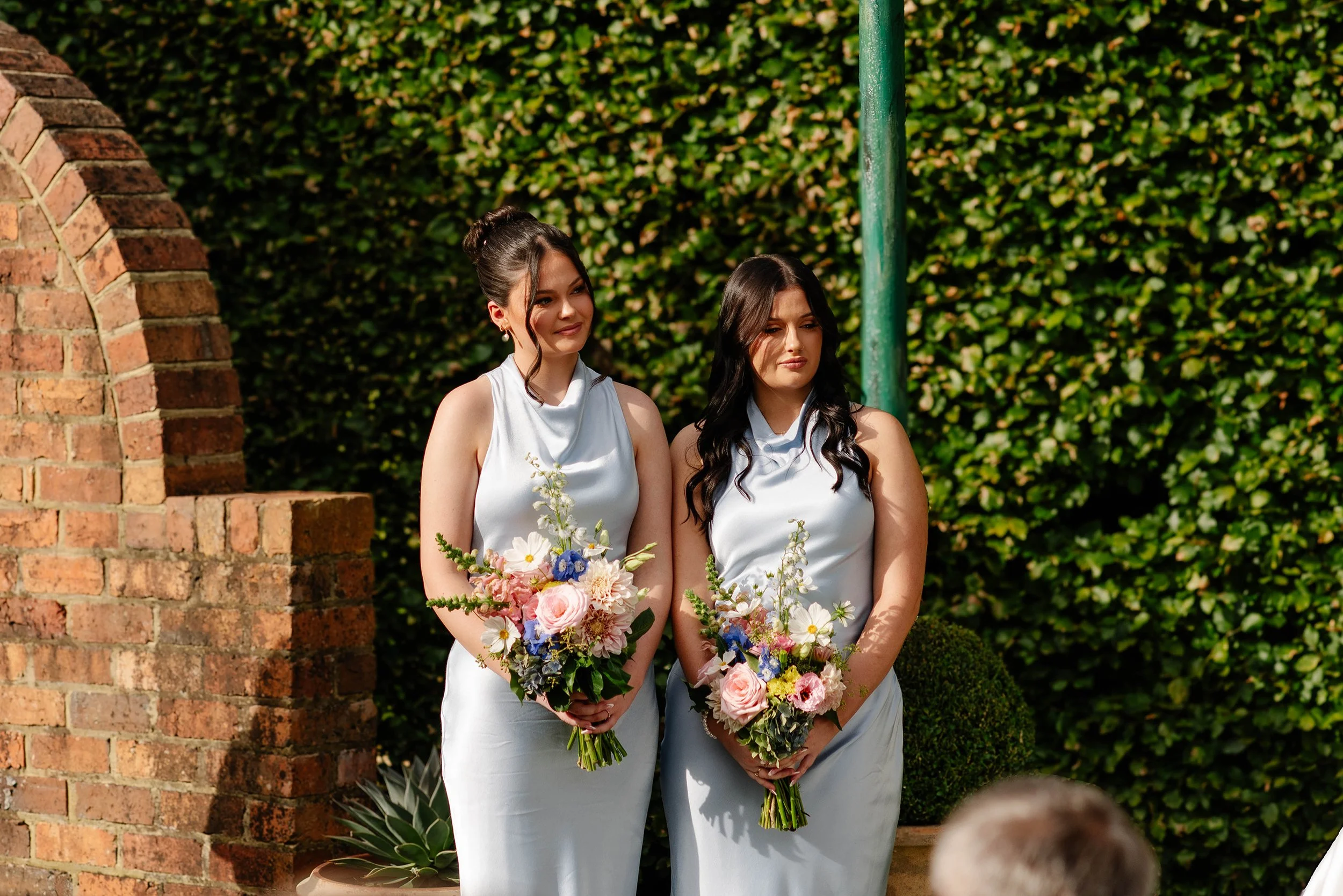 bridesmaids-stand-at-arbor-smiling.jpg