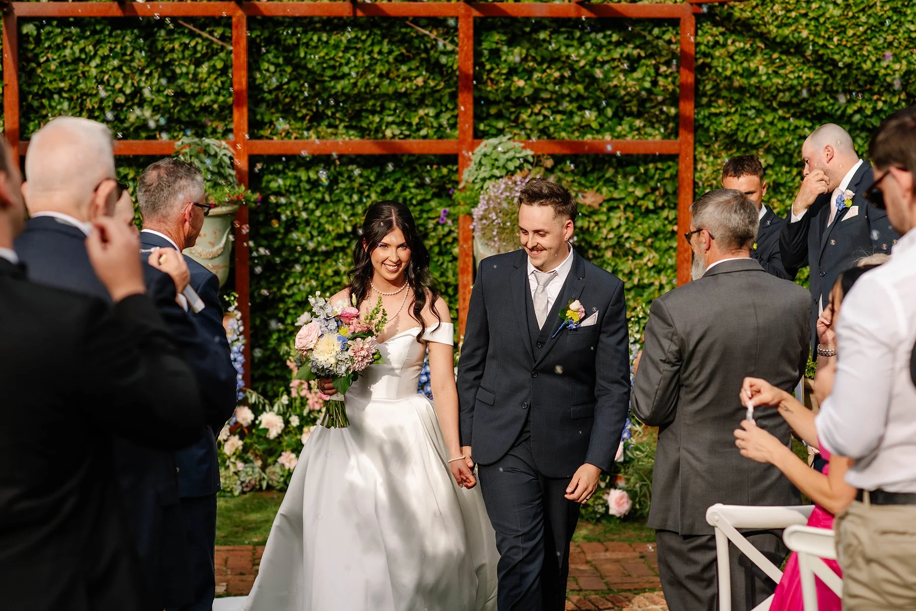 bride-groom-hold-hands-confetti-exit.jpg