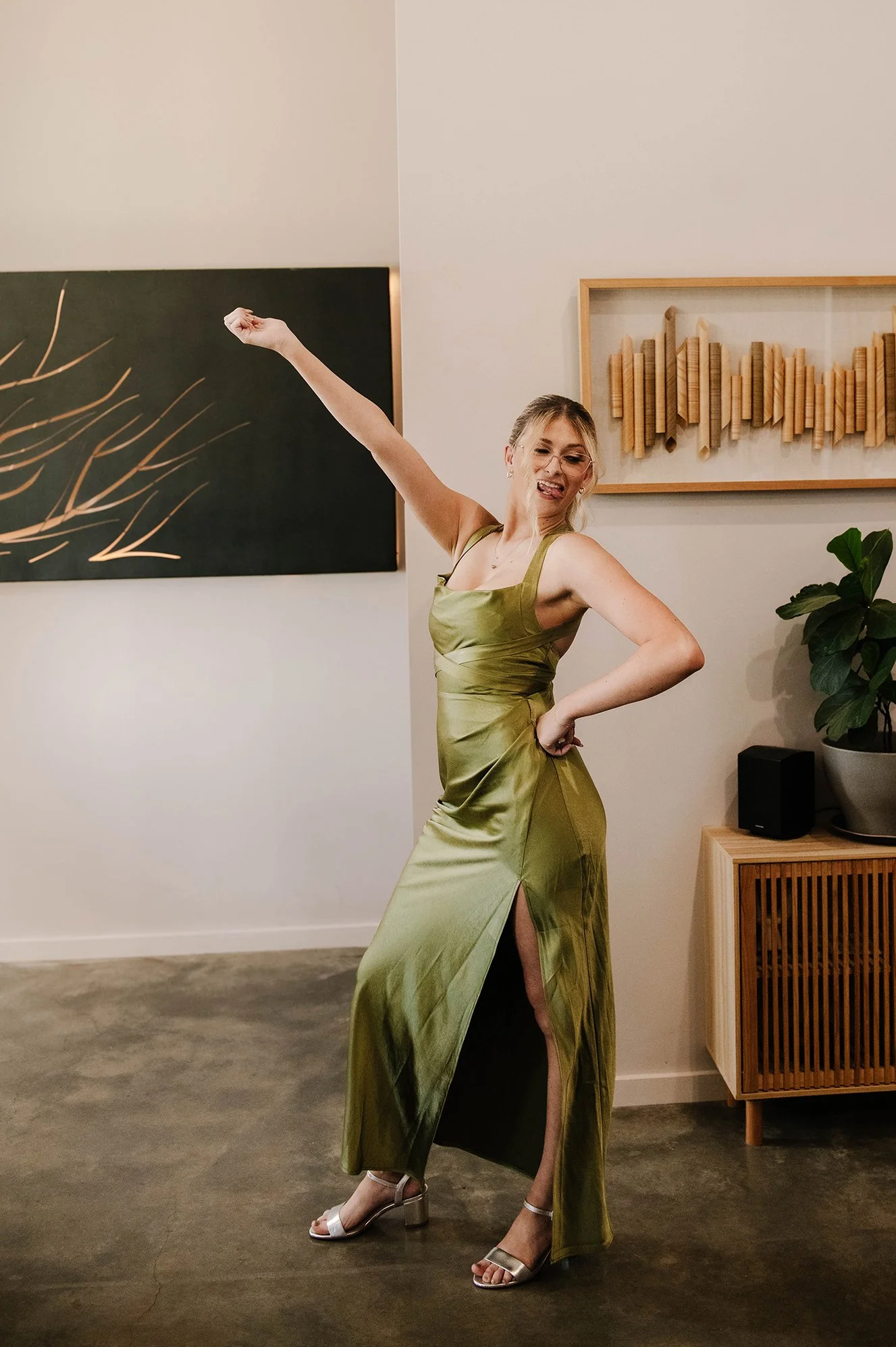 Bridesmaid in green dress poses with arm in the arm after doing her first look