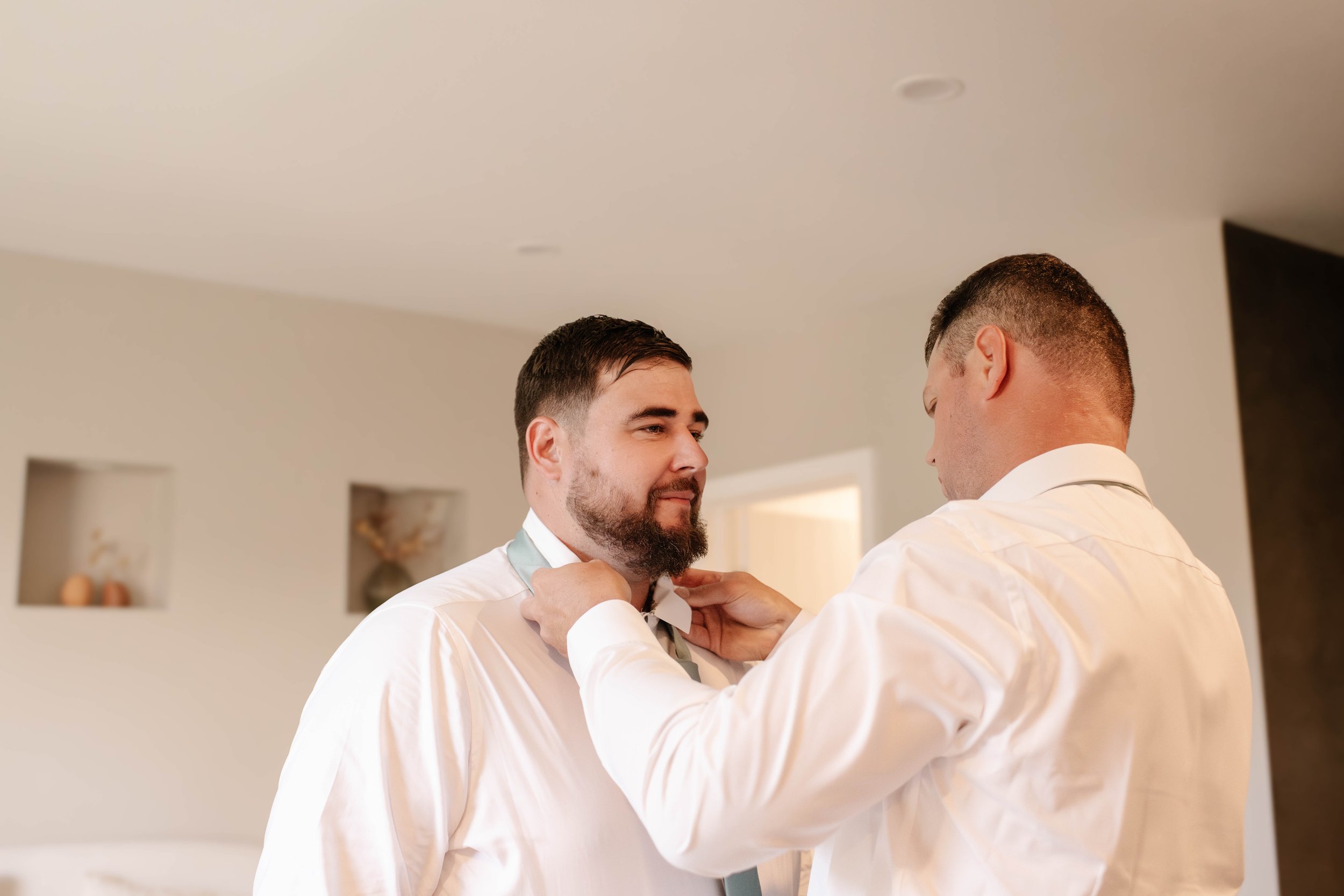 getting-ready-groom-tie-groomsman.jpg