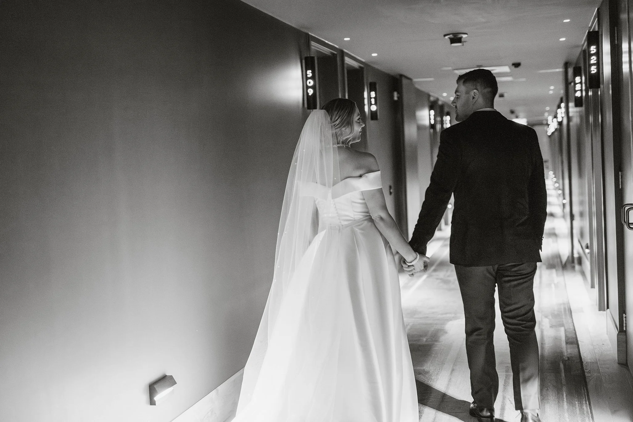 black-white-couple-walk-qt-hotel-hallway.jpg