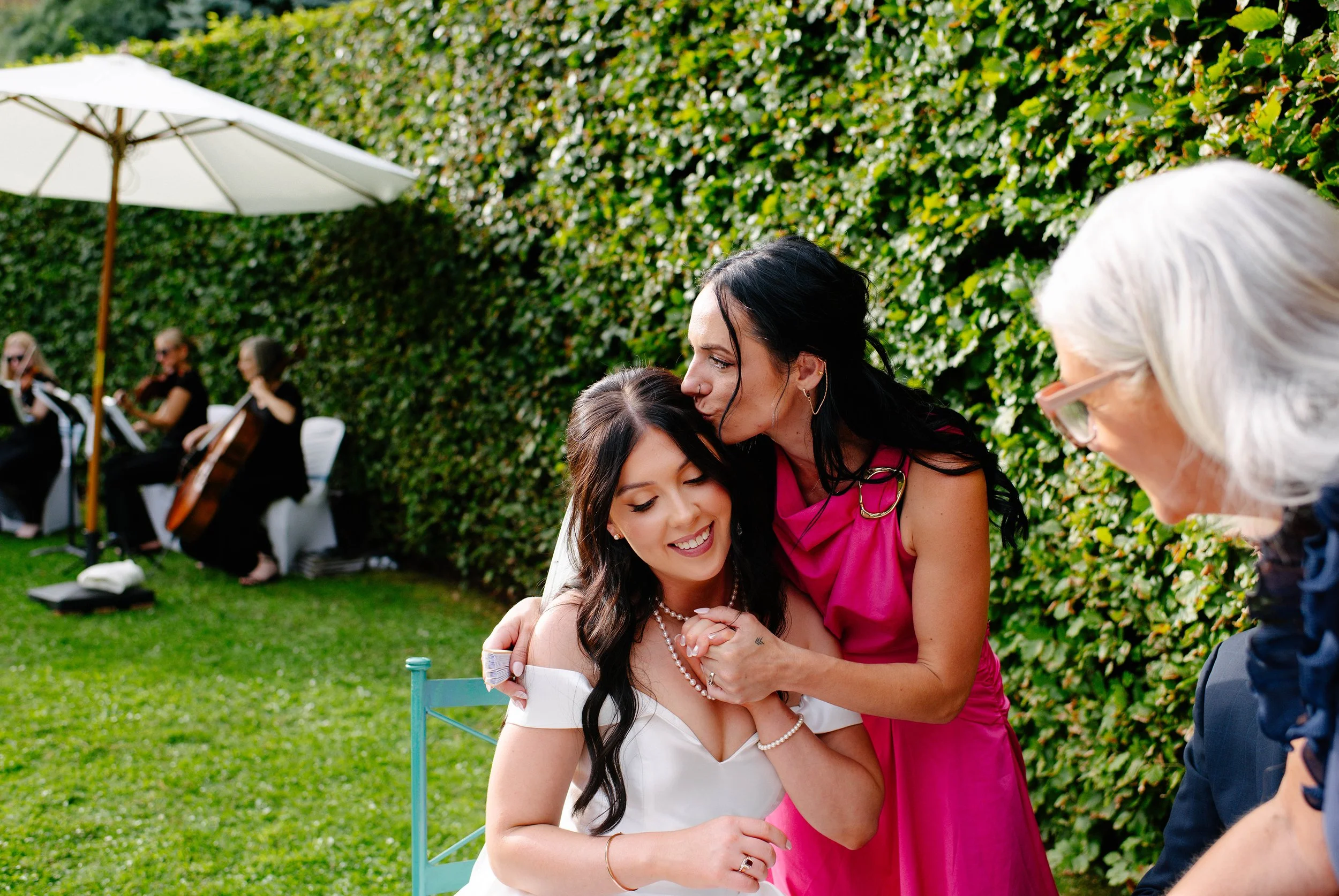 guest-kisses-bride-pink-dress-hedges-olinda.jpg