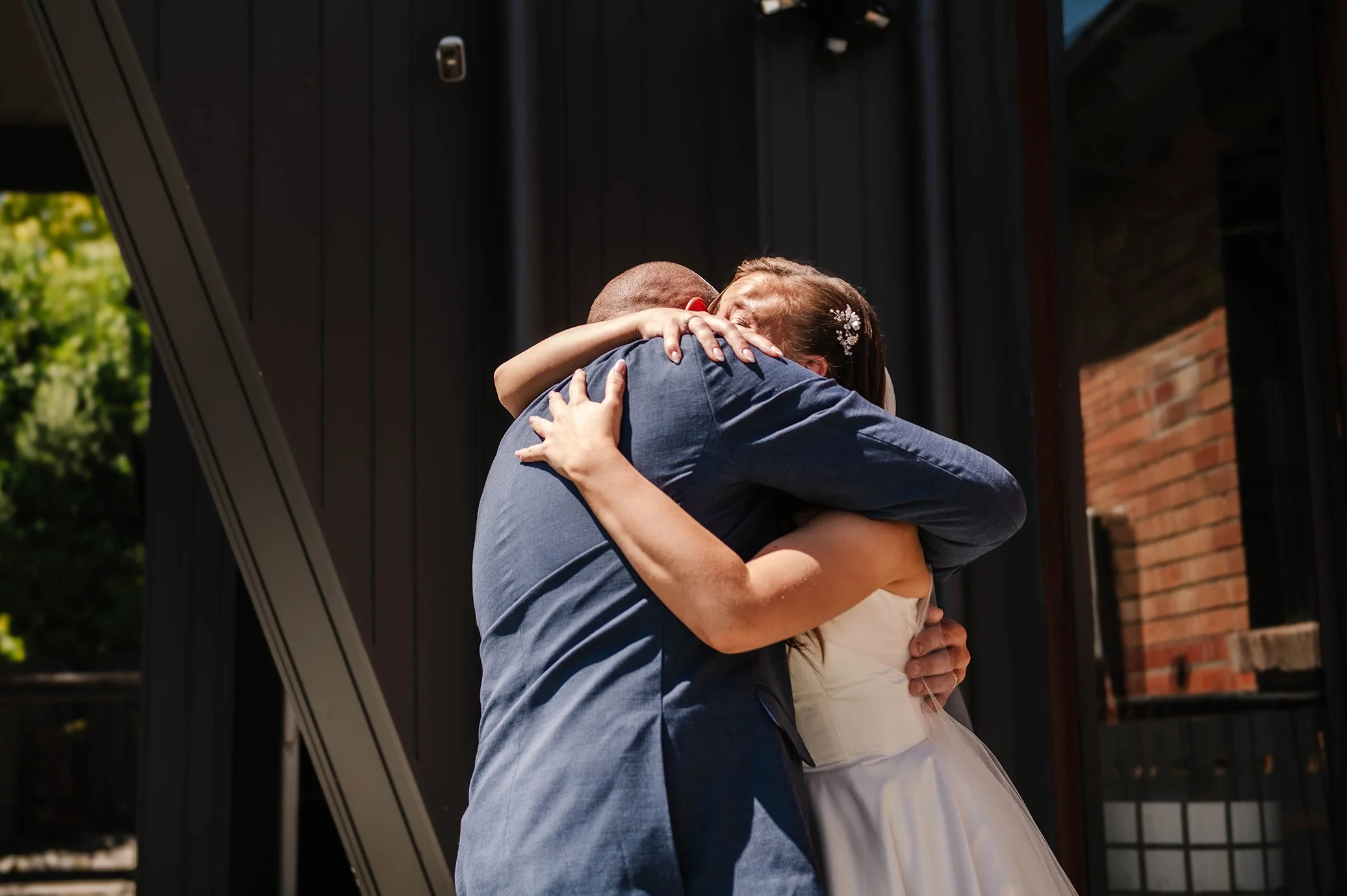 Brides father embraces his daughter at their Ballarat house after first look