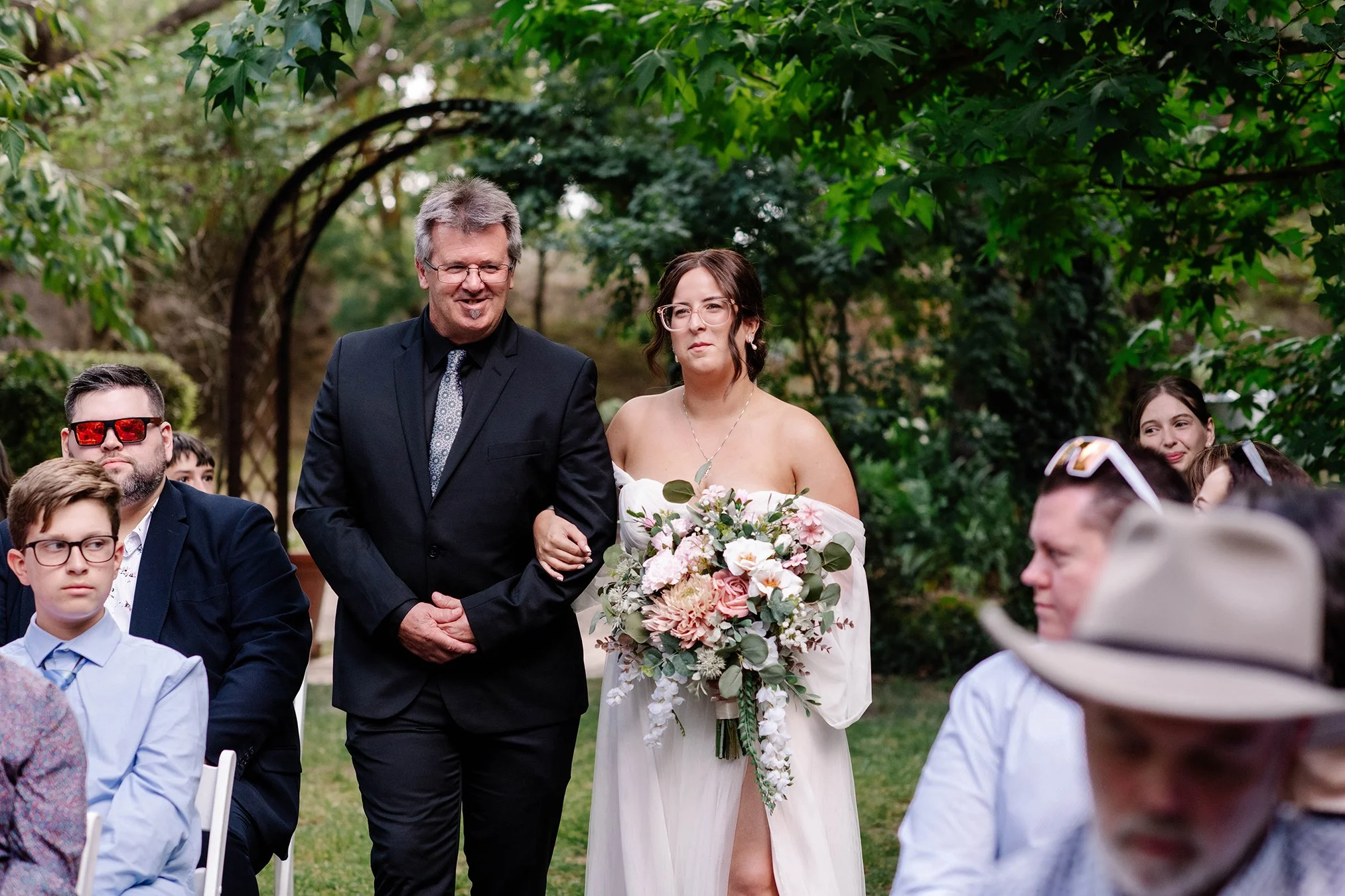 bride and her father walking down the aisle together at Chateau Dore Bendigo smiling