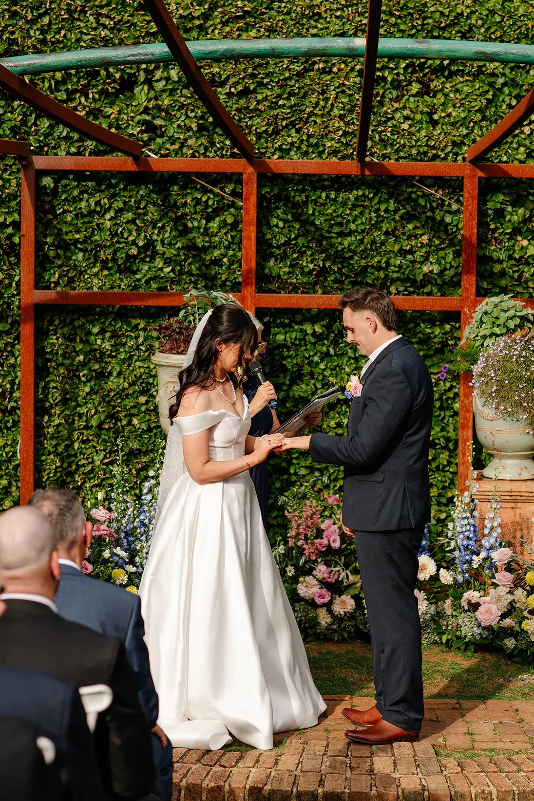 bride-puts-groom-ring-olinda-garden-ceremony.jpg