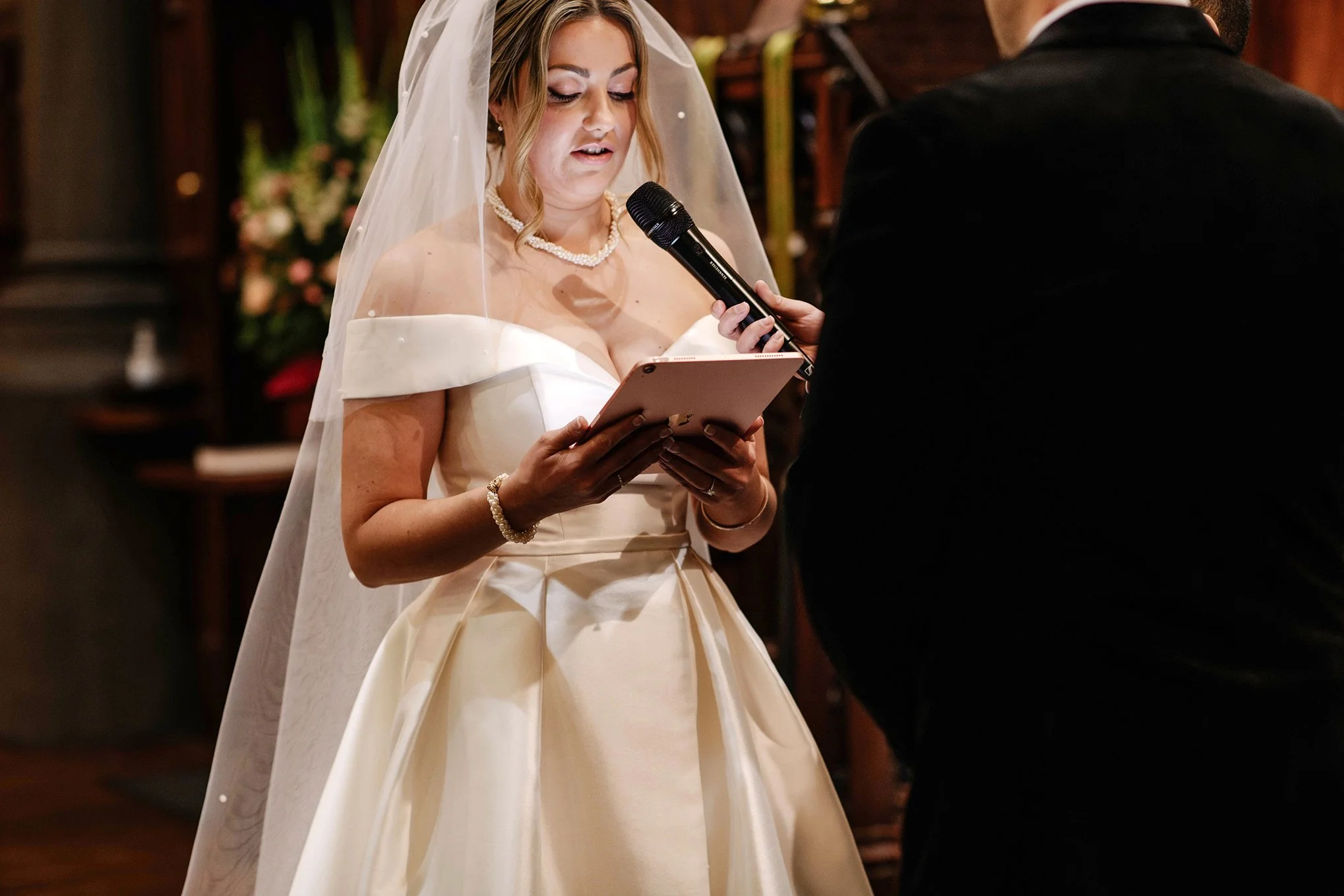 brides face lit up as she looks down and reads vows at Melbourne church wedding