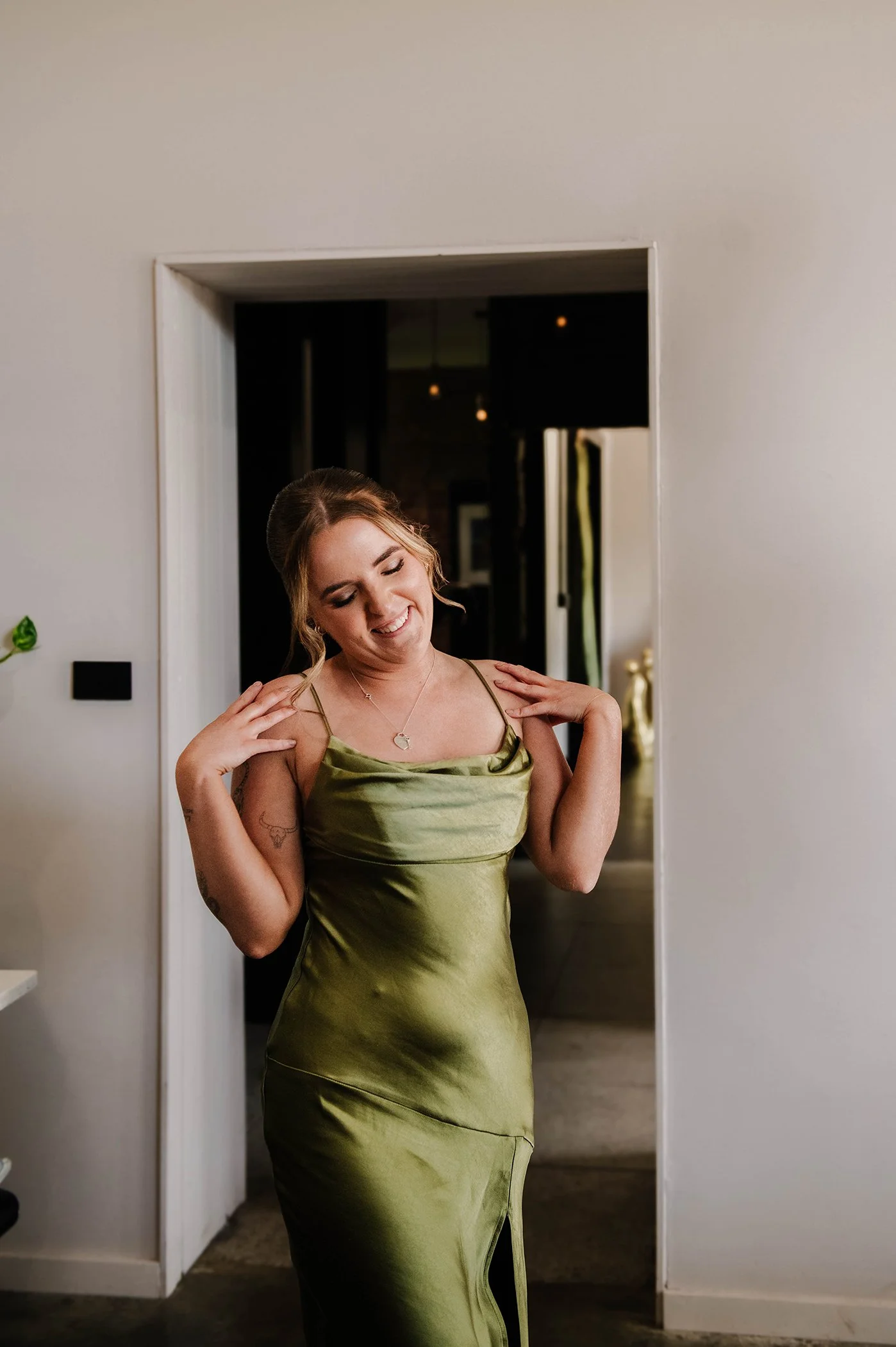 Bridesmaid first look as she smiles shyly with her hands to her shoulders