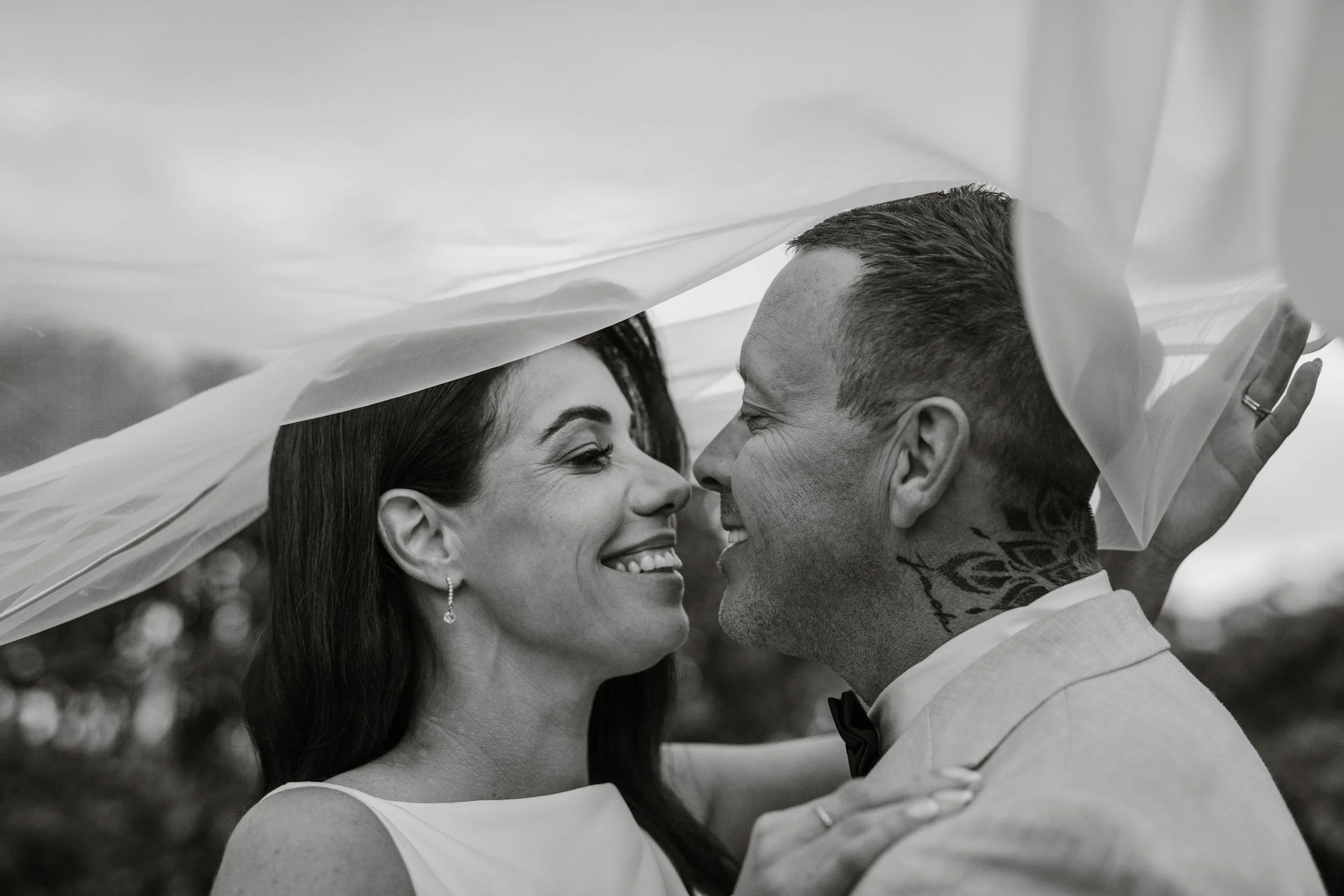 Bride and groom smiling at each other under a flowing veil at Jason's Restaurant Beaconsfield wedding