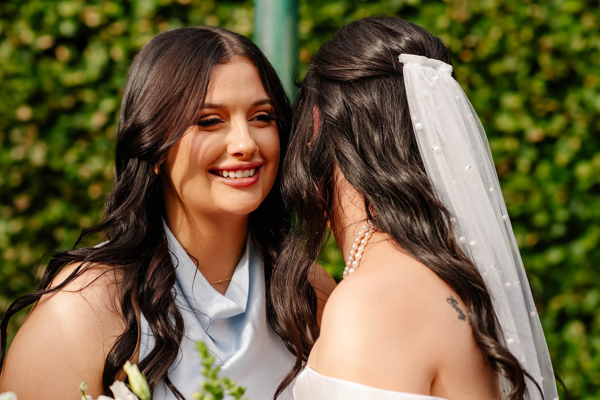 bridesmaid-smiling-with-cheek-to-bride.jpg