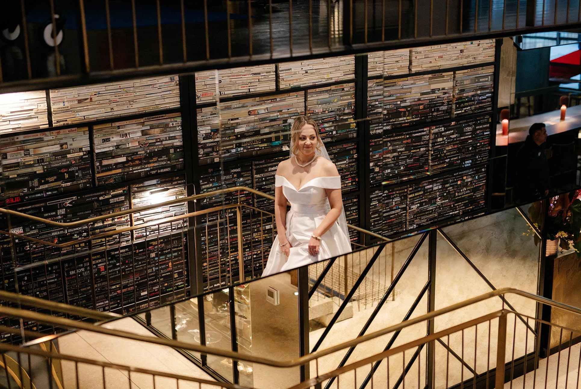 colour photo of bride smiling at the camera in her reflection on the stairs of QT Hotel Melbourne