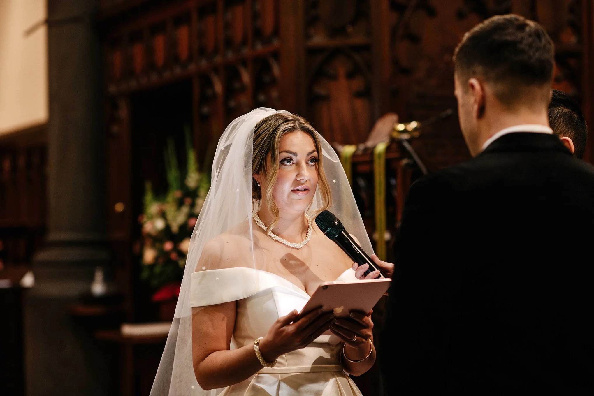 brides face lit up as she reads vows at Melbourne church wedding