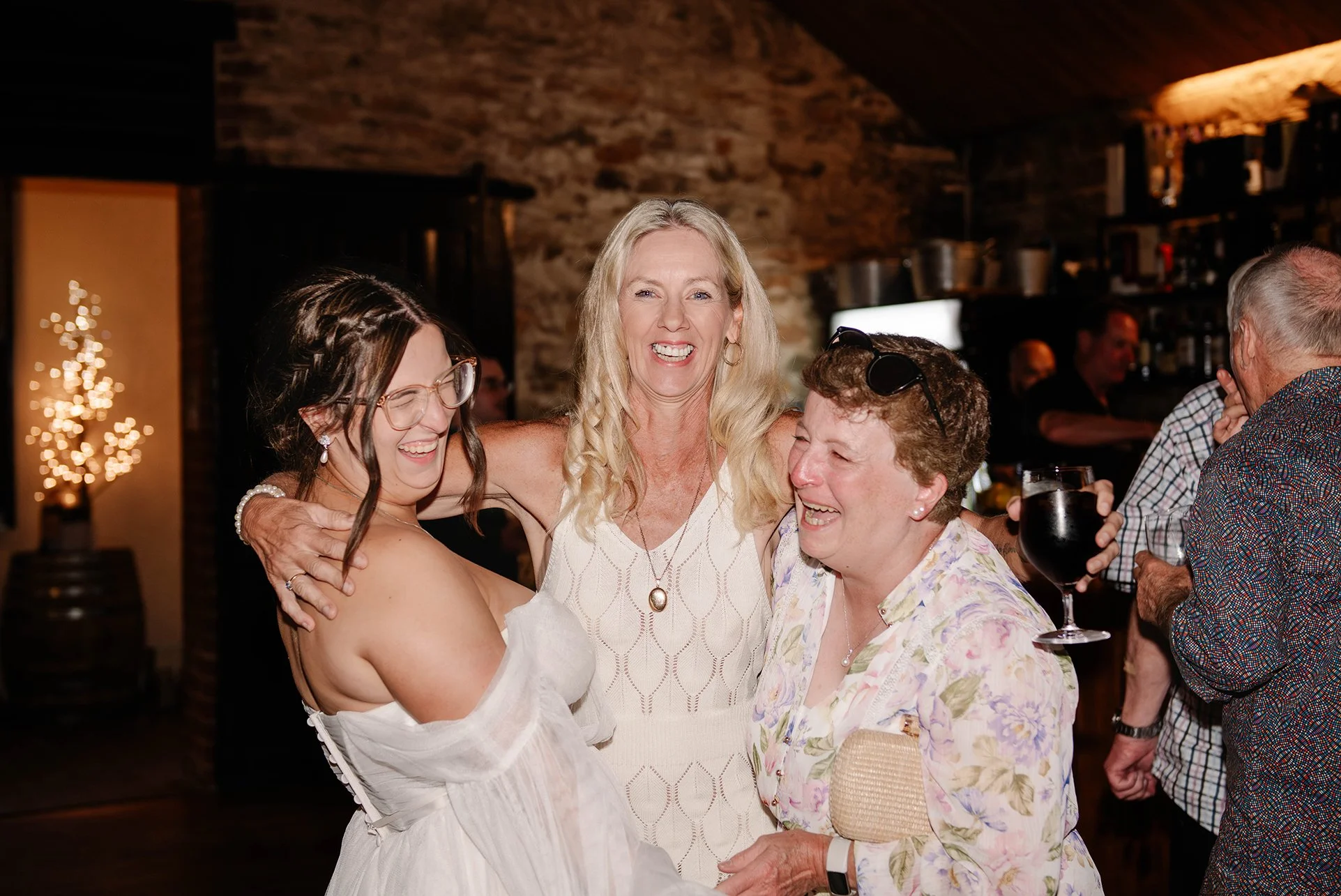 two guests laugh and hug bride at wedding reception in Chateau Dore Bendigo venue