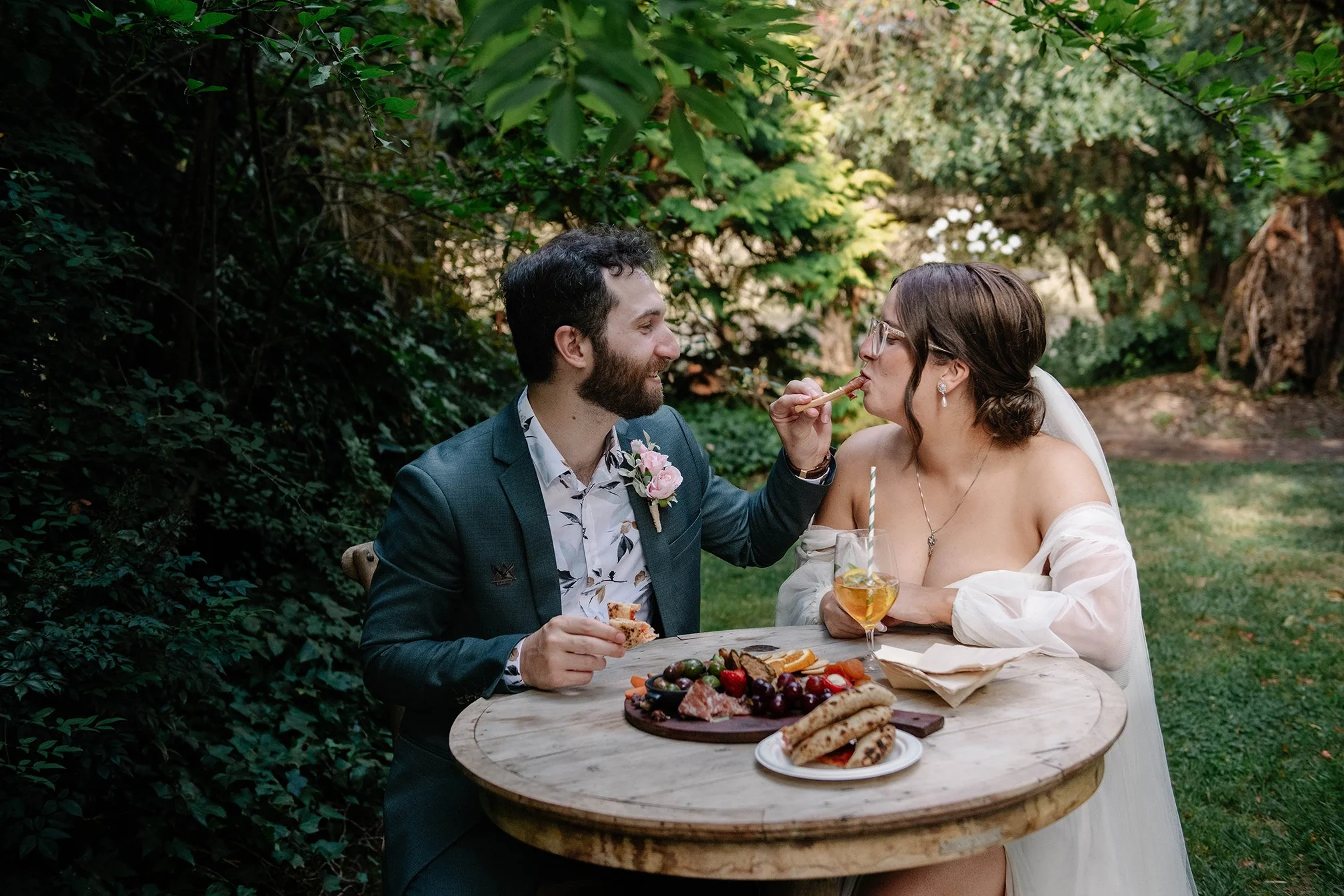groom-feeds-bride-garden-table-chateau-dore.jpg