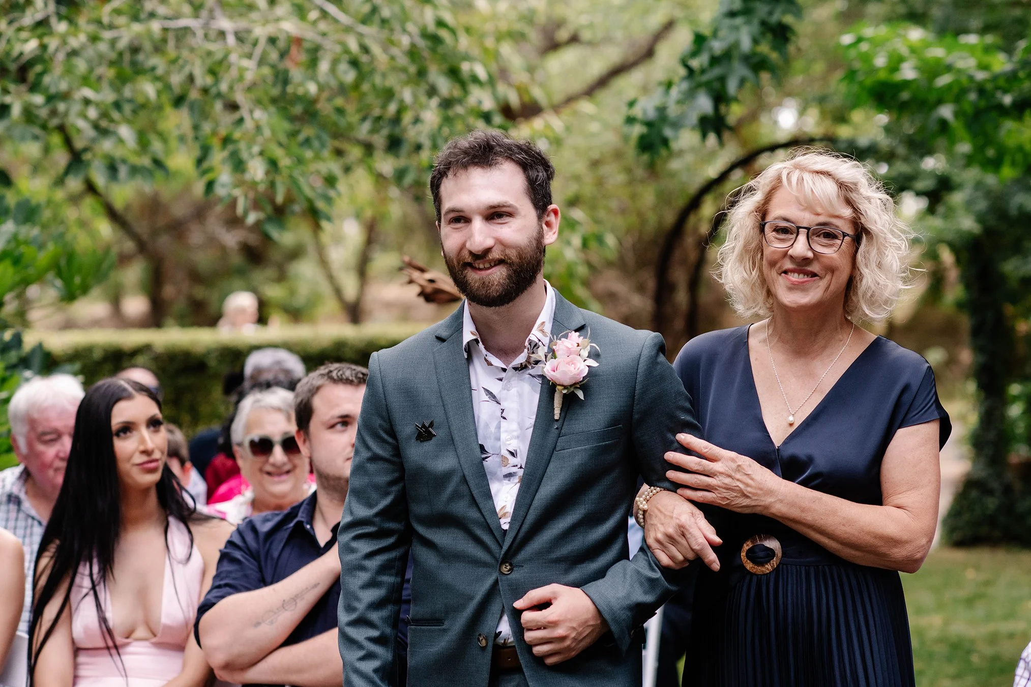 groom and his mother walking down the aisle together at Chateau Dore Bendigo smiling