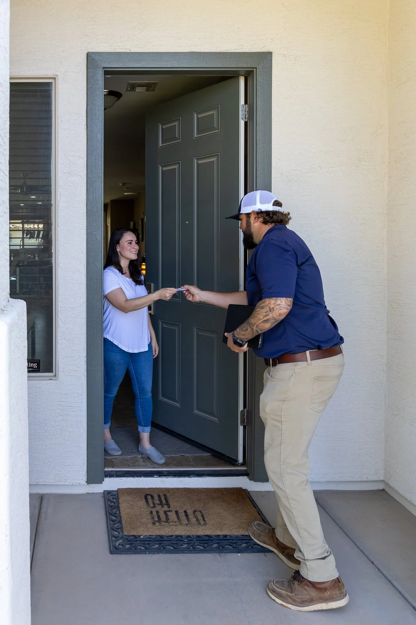 Varsity pest technician handing business card to homeowner in Arizona