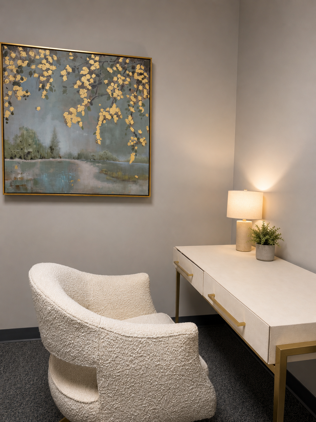 Office set up with cream chair at a cream desk and gold detailed picture