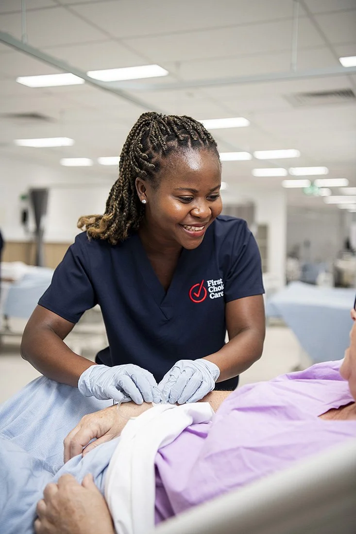 Woman nurse assisting a patient in a hospital bed