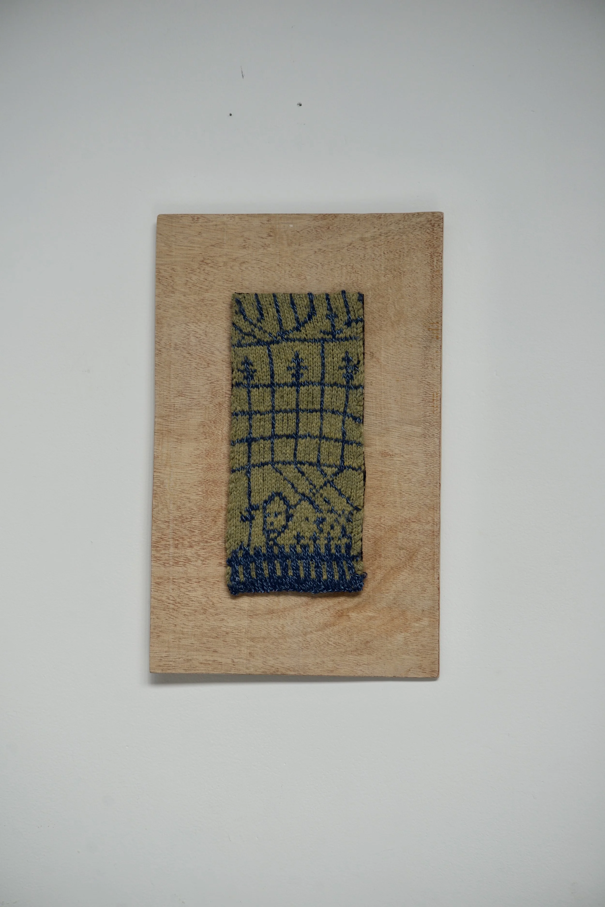 Cage, 2026. Knitted wool mounted on wood. 5x11 inches (including frame). 