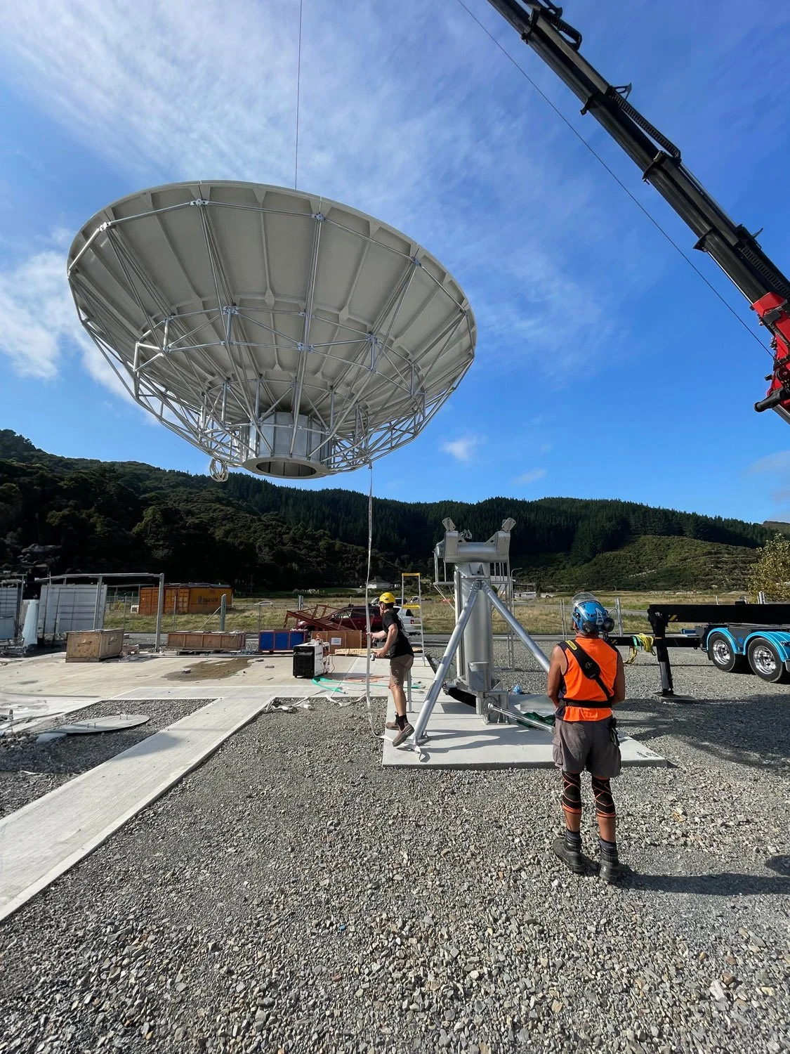 Installation of a large satellite Earth Station antenna during construction of a ground station communications facility.