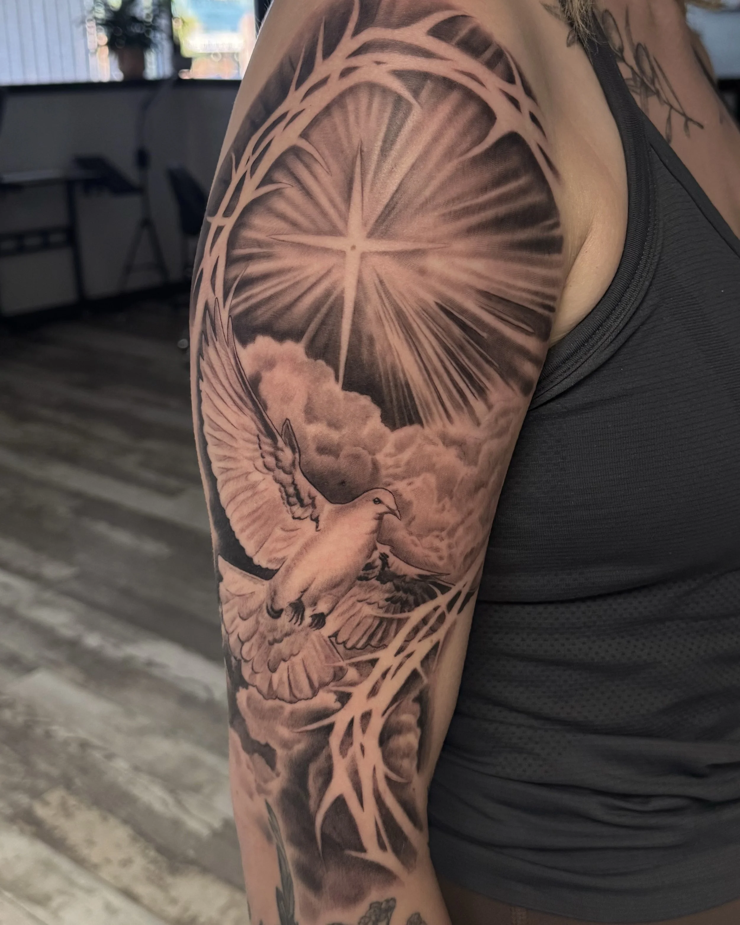Religious tattoo black and gray on upper arm