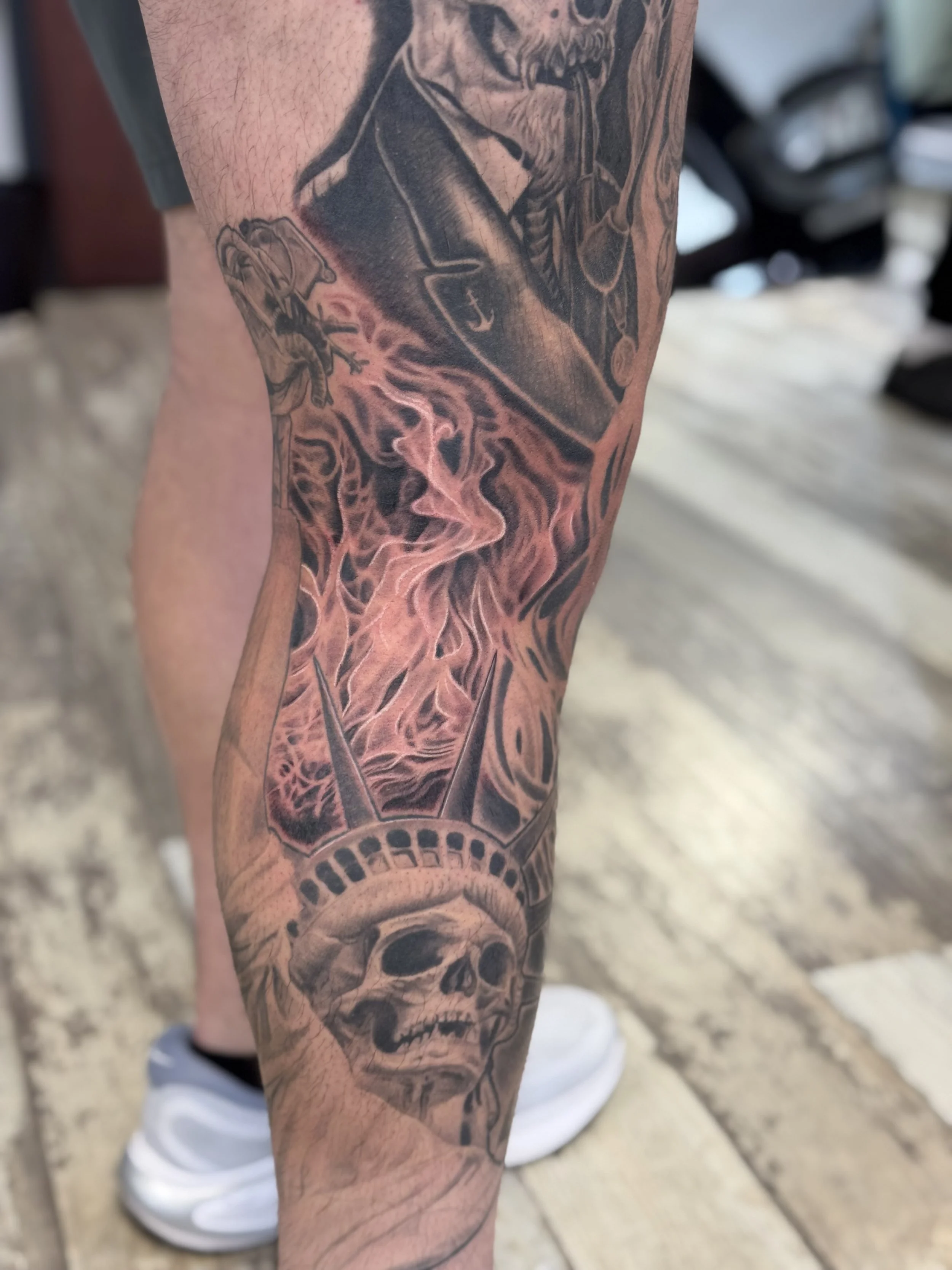 black and gray fire tattoo with skull liberty statue
