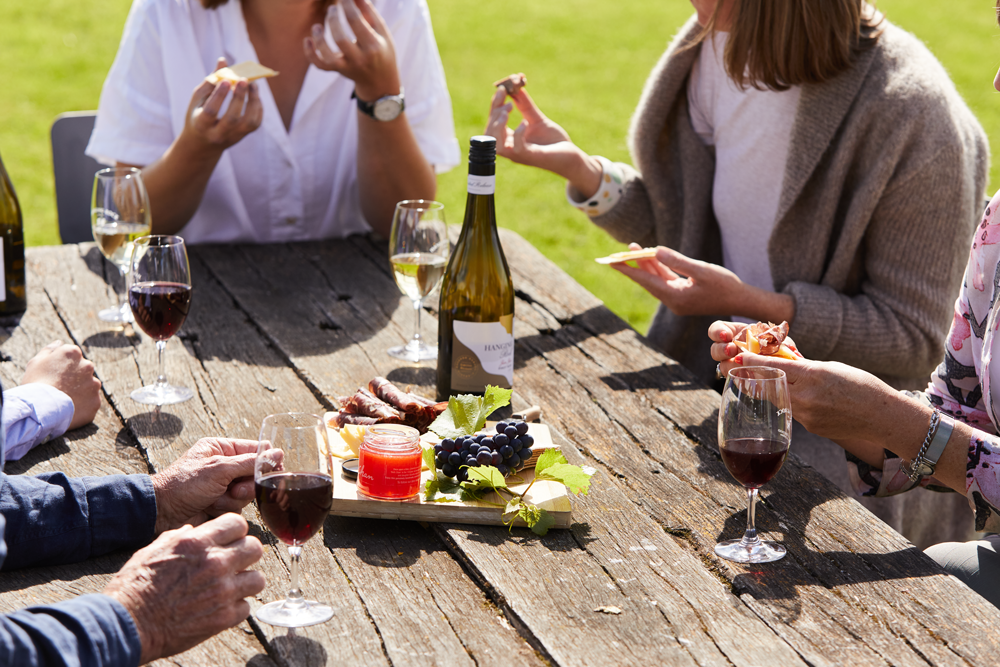 glass of wine and cheese platter outside at hanging rock winery