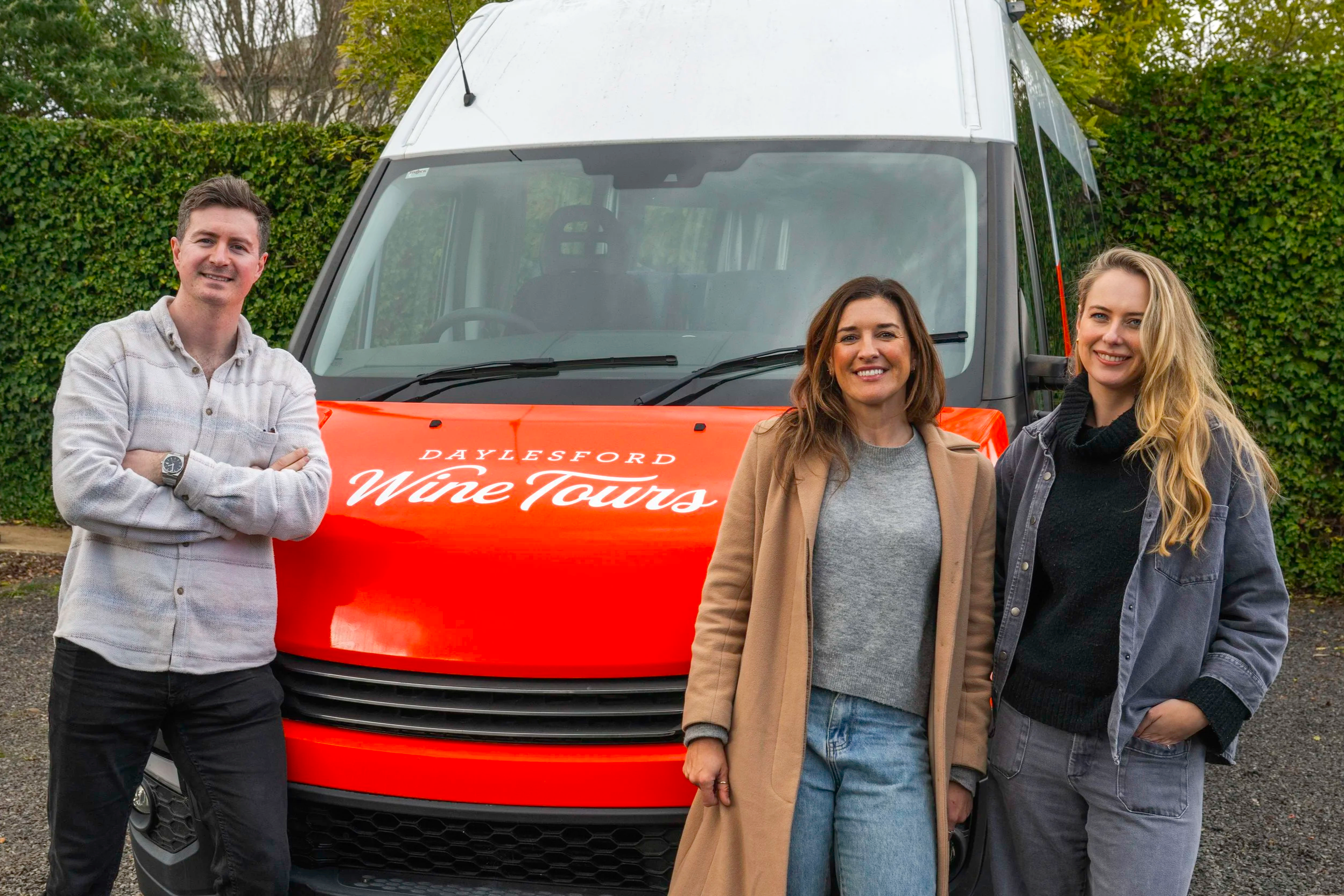 A group stood in front of a vehicle