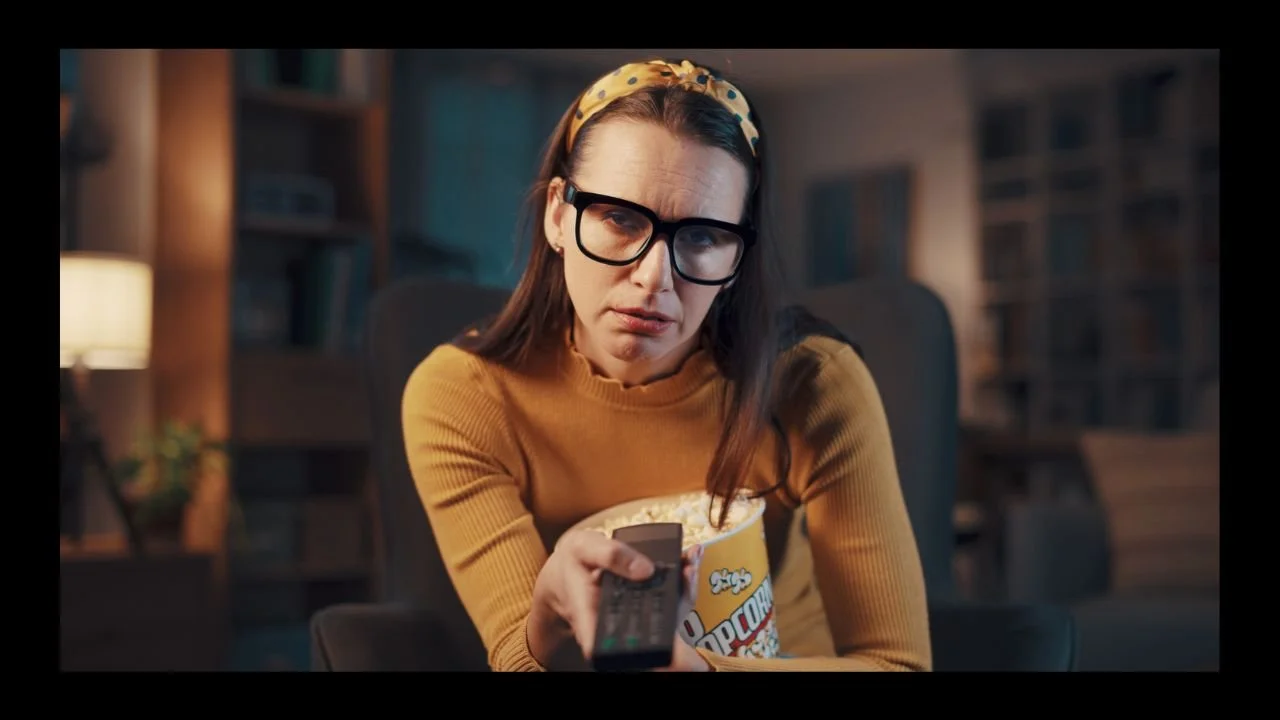 a woman looking somewhat confused by what she's watching on TV