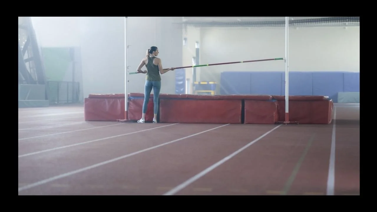 A female high jumper resetting the bar