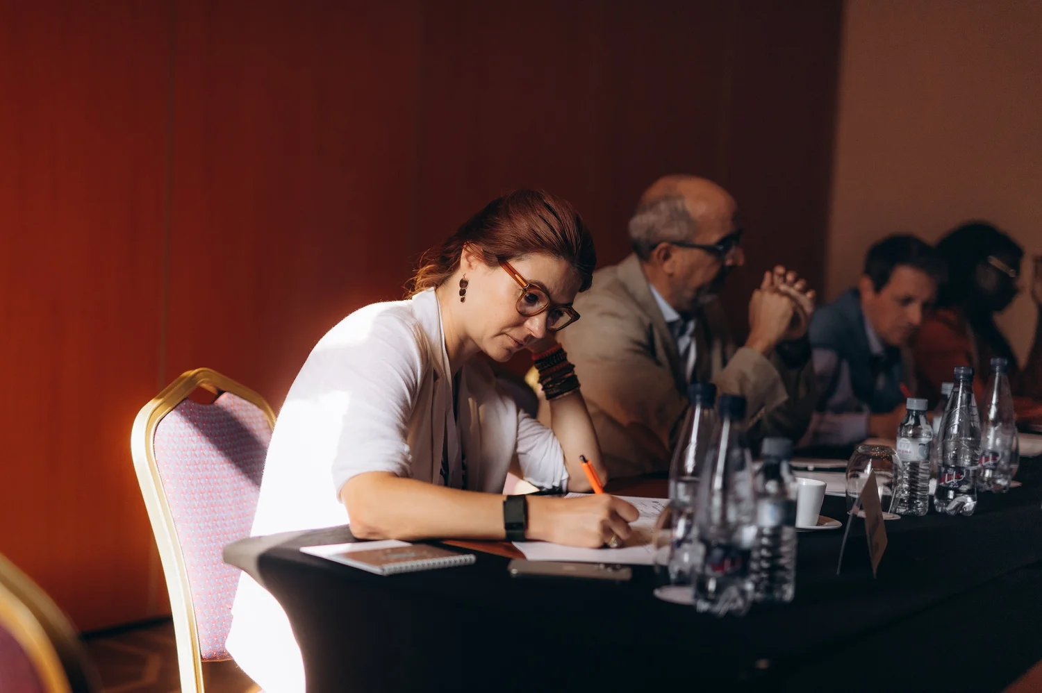 A member writing notes at the table during a CEO CF group session.