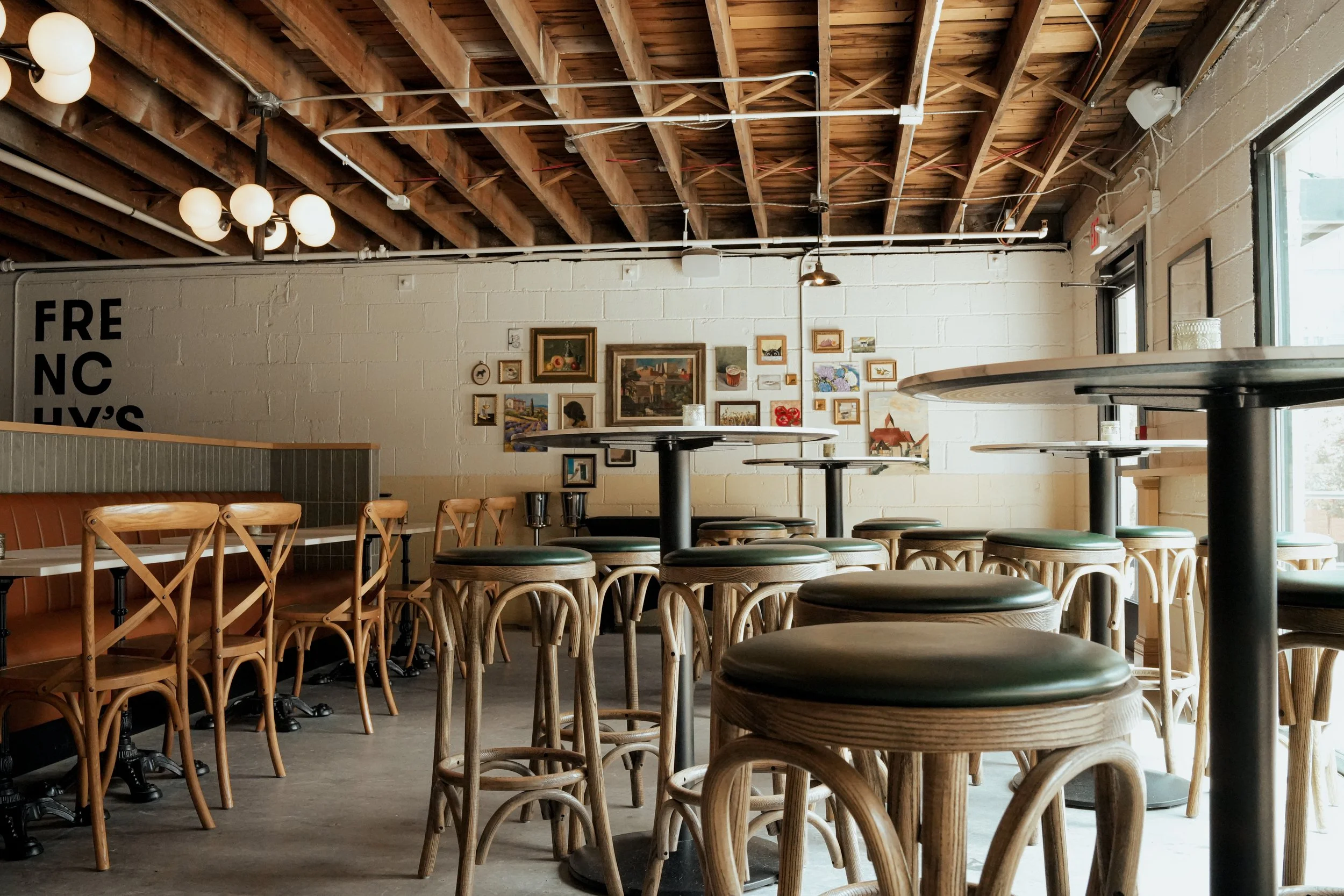 Inside of wine shop with seating and gallery wall.