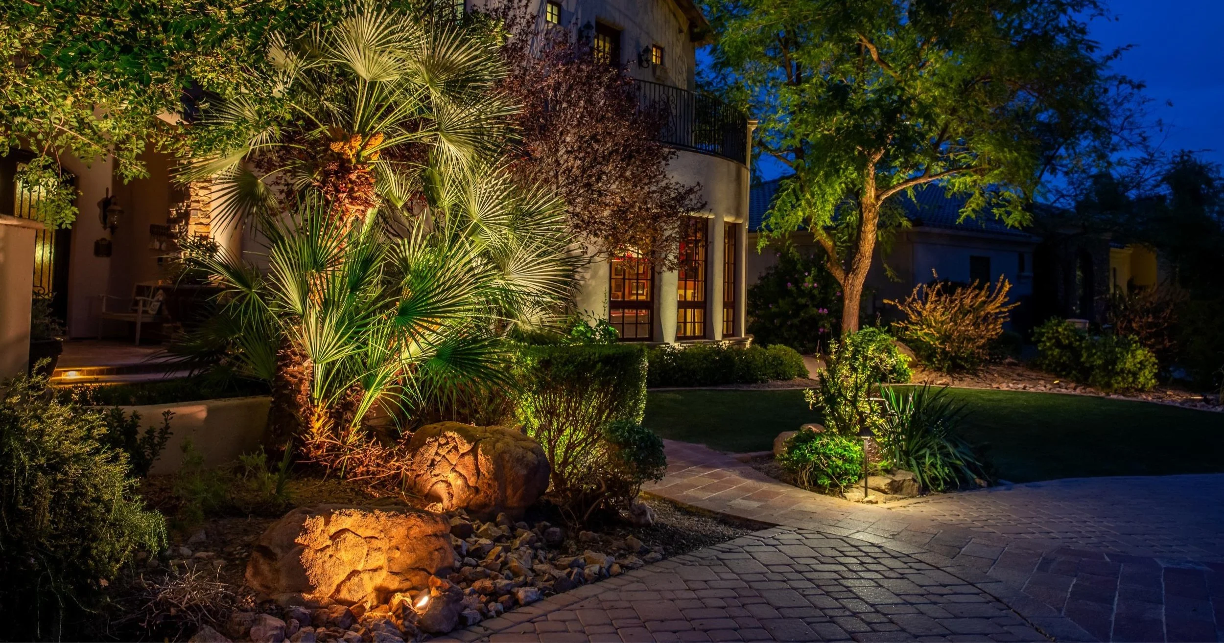 Outdoor lighting in entryway with paver walkway