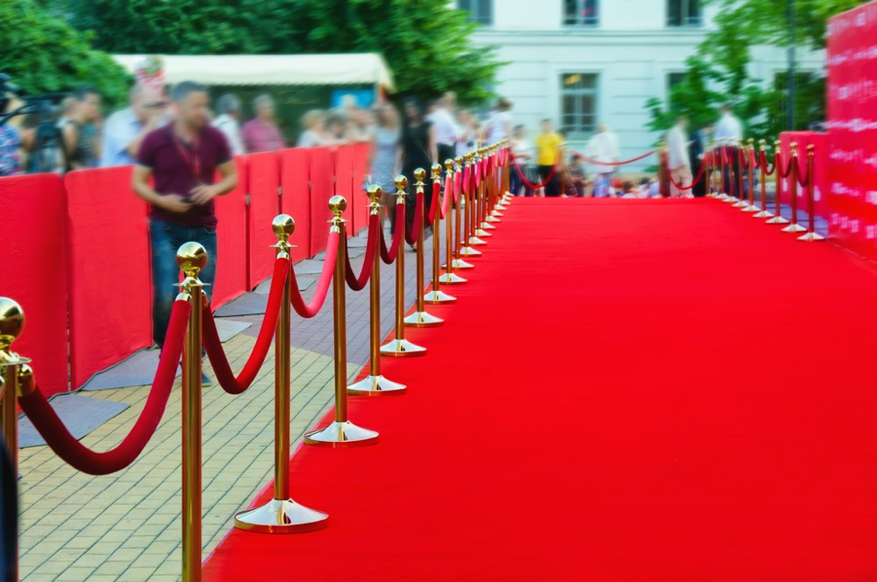 Empty red carpet with gold stanchions before an awards show, symbolizing creating a personal A-List based on trust, not status.