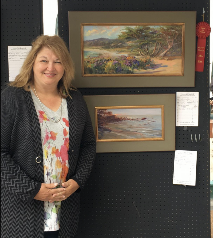 Artist  Liz Bonham at Show with paintings and Ribbons