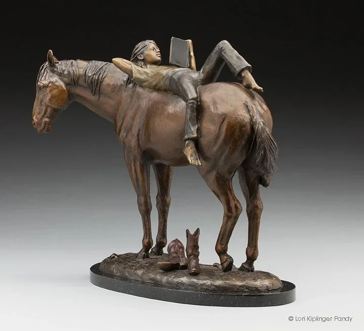 Sculpture of child reading on the back of a horse by Lori Kiplinger Pandy