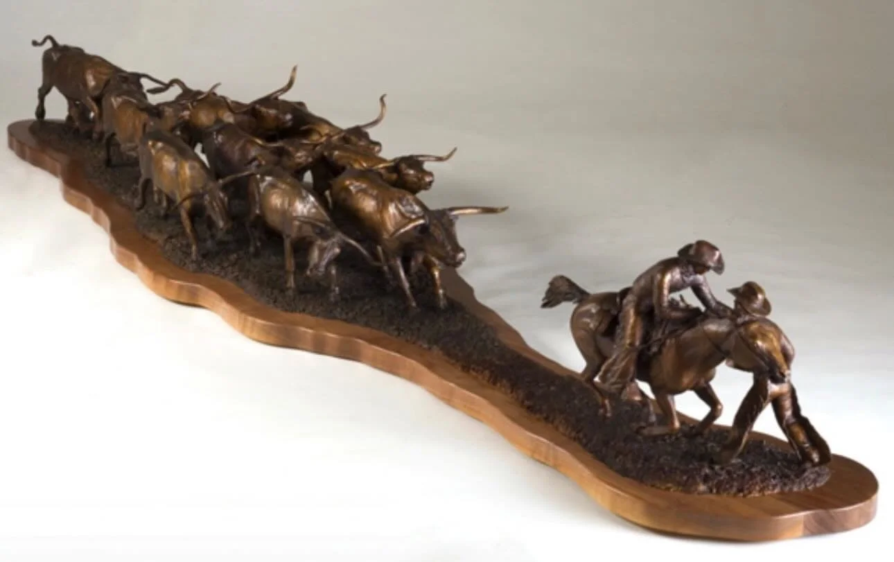 Bronze sculpture of a mounted cowboy saving a cowboy on foot from a her of stampeding cattle by Christy Daniels