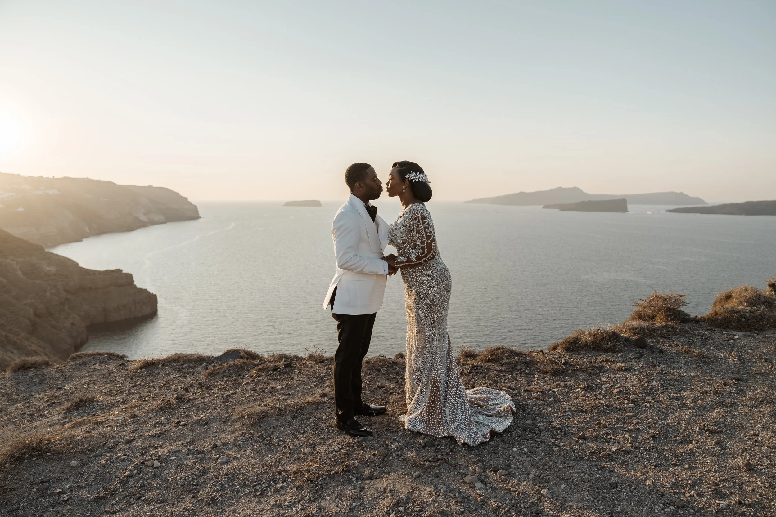 Bride and groom overlooking the Aegean Sea in Santorini, Greece, during their destination wedding.