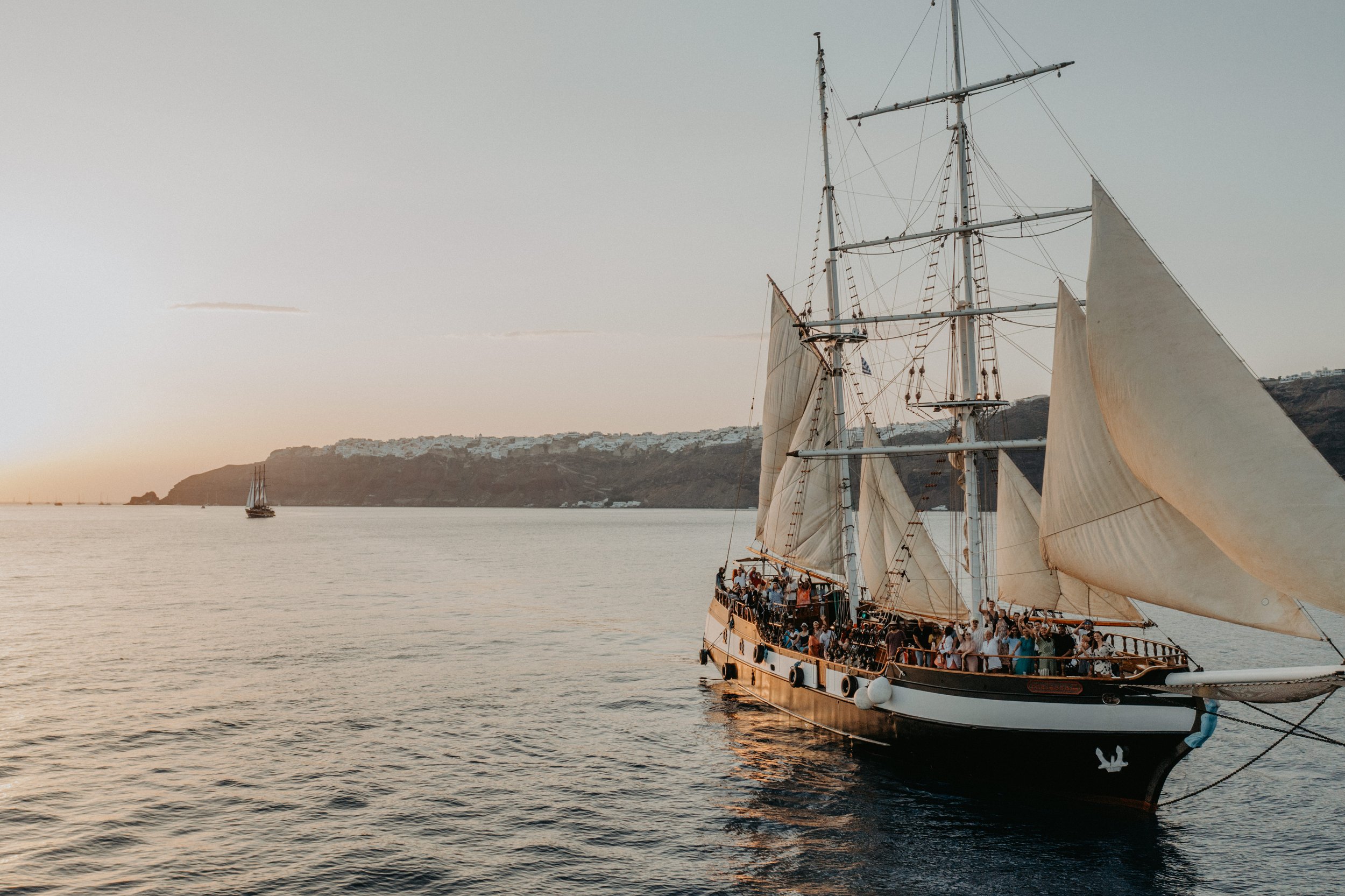 Wedding guests enjoying a sailing experience during a destination wedding weekend in Santorini, Greece