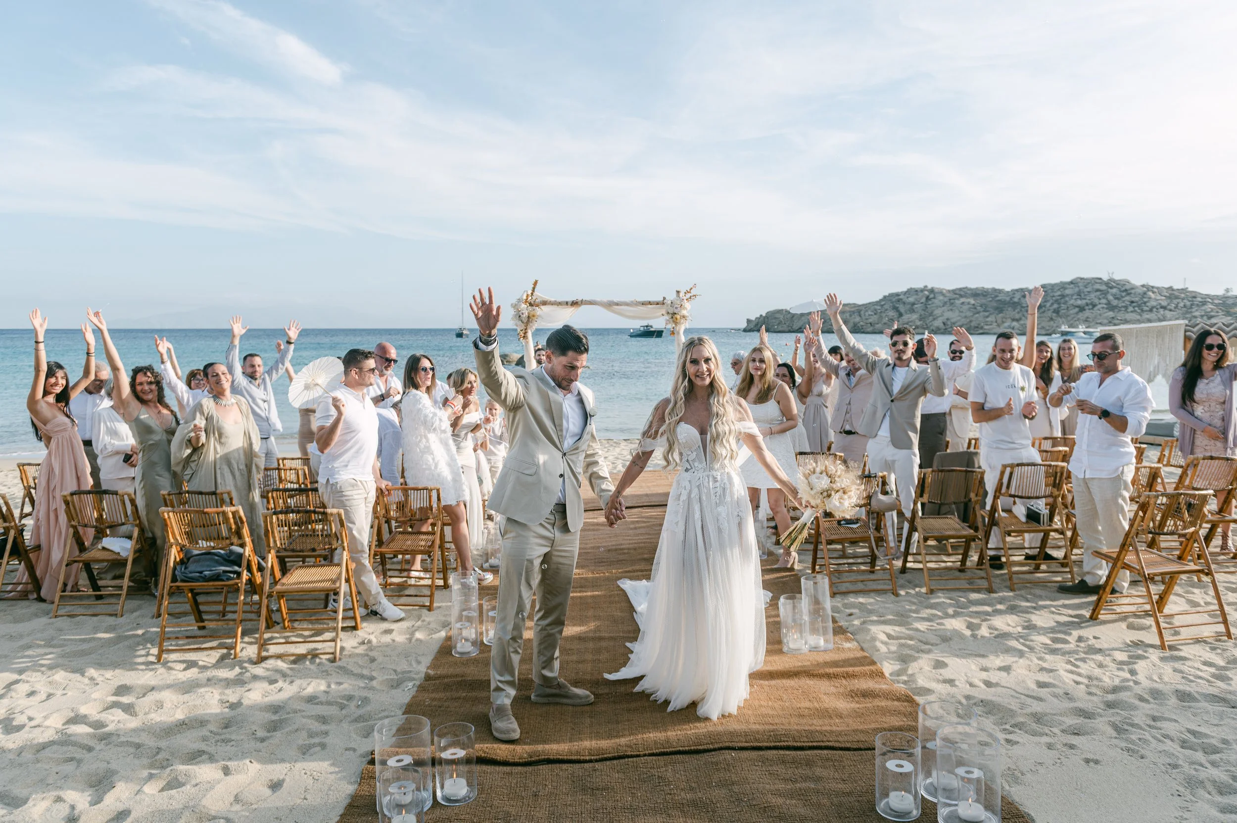 Newlywed couple celebrating with their guests after their luxury beach wedding in Mykonos, Greece