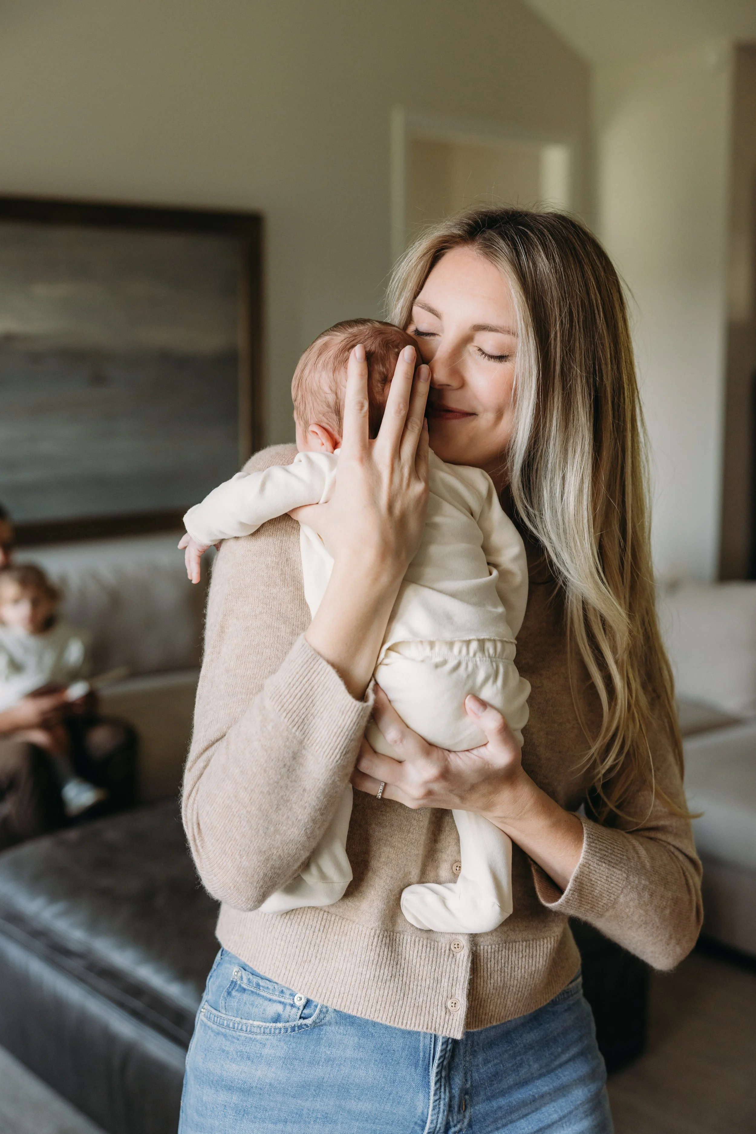 Mom Holding Newborn Baby in living room