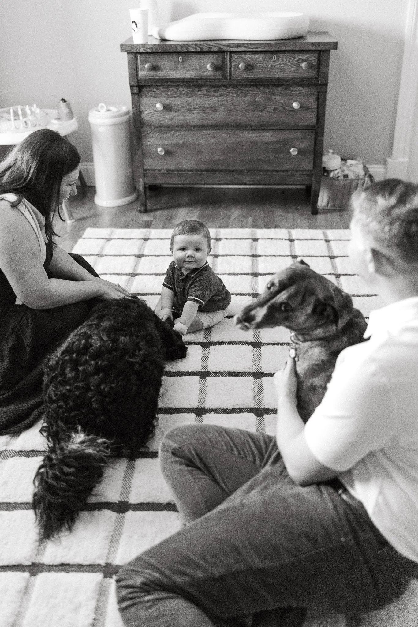 Baby playing with dogs in his nursery