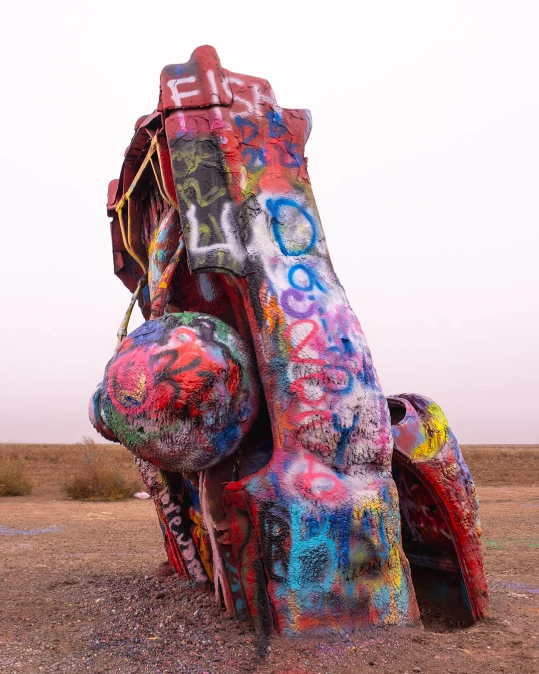 Cadillac Ranch
Amarillo, Texas
35.1870&deg; N, 101.9873&deg; W

Cadillac Ranch was installed in 1974 as a public art project meant to be changed by anyone who stopped. The cars were buried nose down at a consistent angle, creating a simple structure 