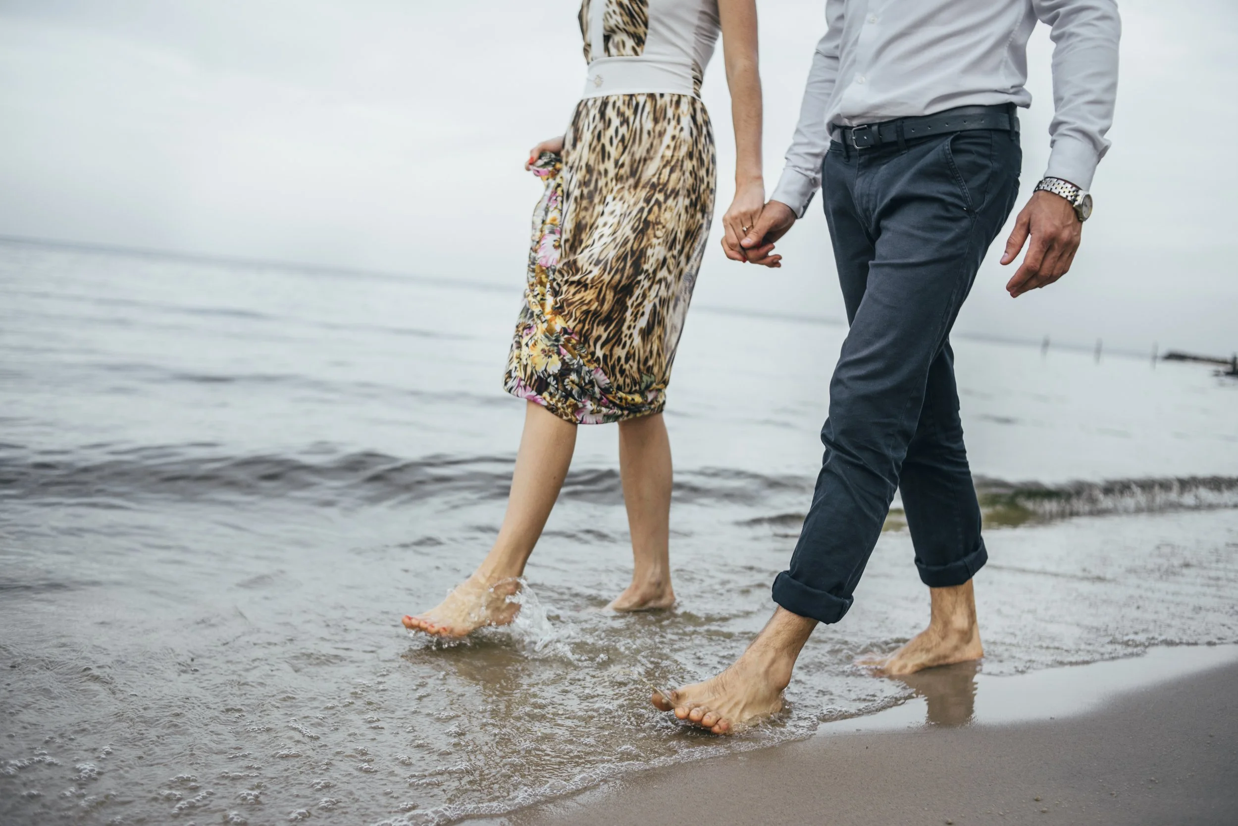 vecteezy_couple-walking-barefoot-on-a-beach_2245218.jpg