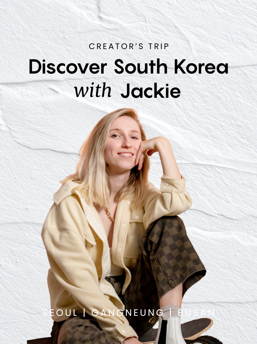 A young woman with blonde hair, smiling and sitting cross-legged on the floor, wearing a beige jacket, brown checkered pants, and white boots, against a white textured background with text about a travel experience to South Korea.
