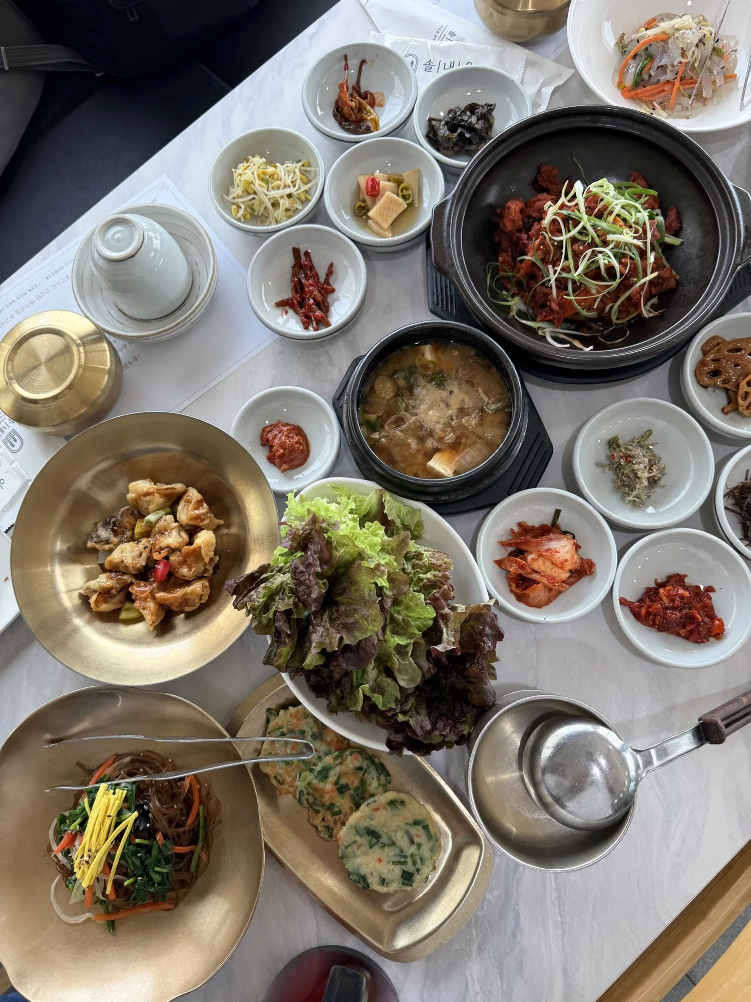 A Korean lunch table with a main dish and many small side dishes (banchan)