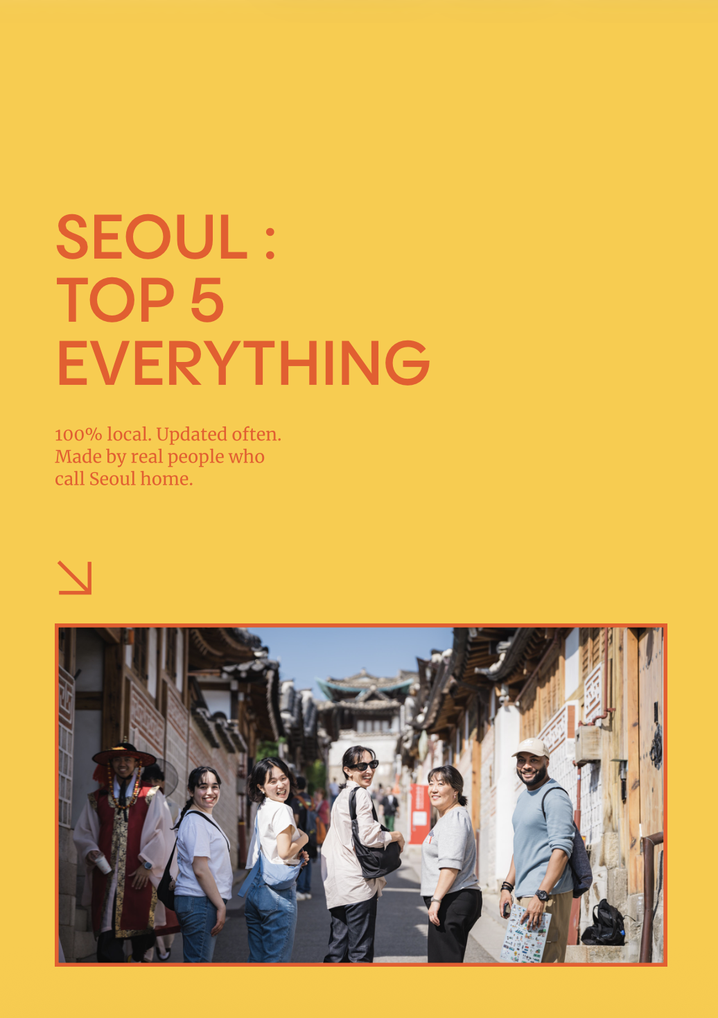 A group of six tourists smiling and posing for a photo on a street in Seoul, South Korea, with traditional Korean buildings in the background.